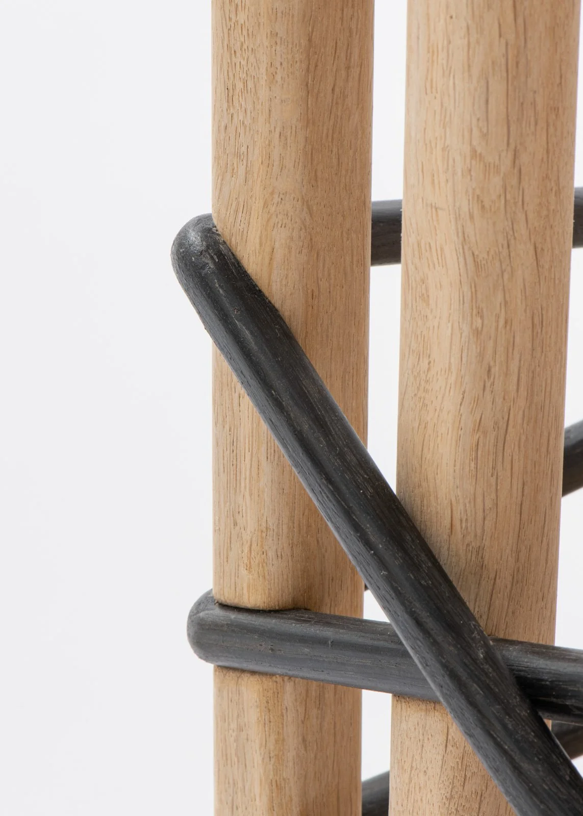 Détail d'une structure en bois avec des barres en métal noir.