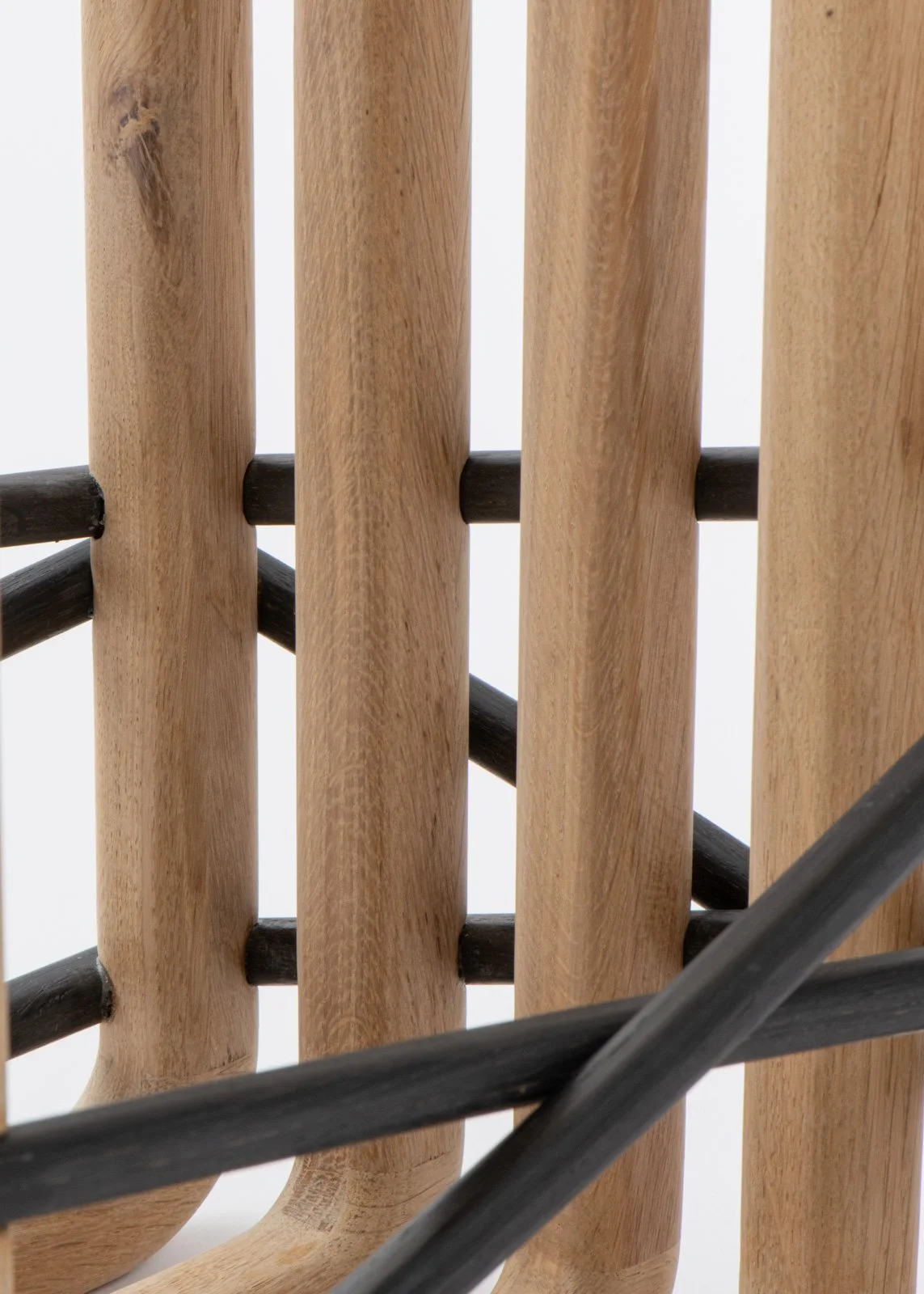 Vue rapprochée d'une structure en bois avec des barres noires croisées.