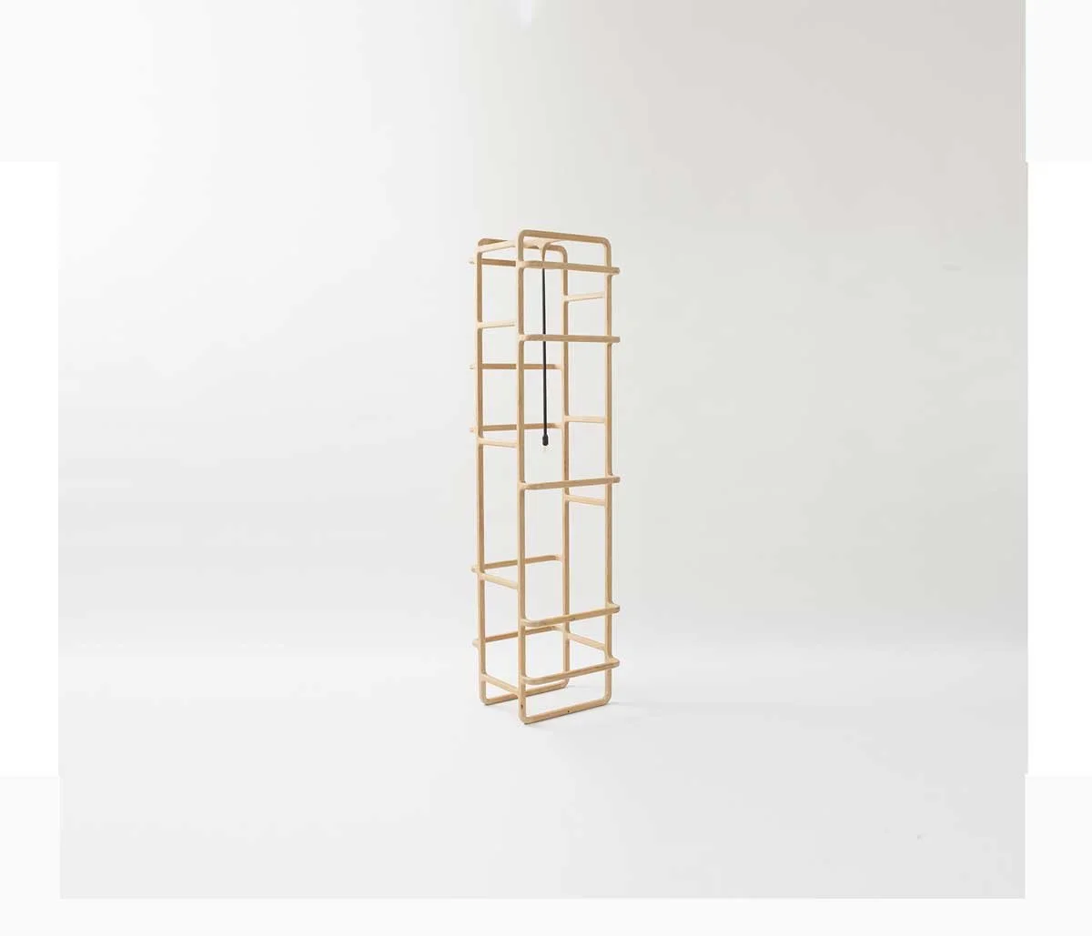 Une structure en bois avec des étagères et une corde noire suspendue au centre, placé contre un mur blanc