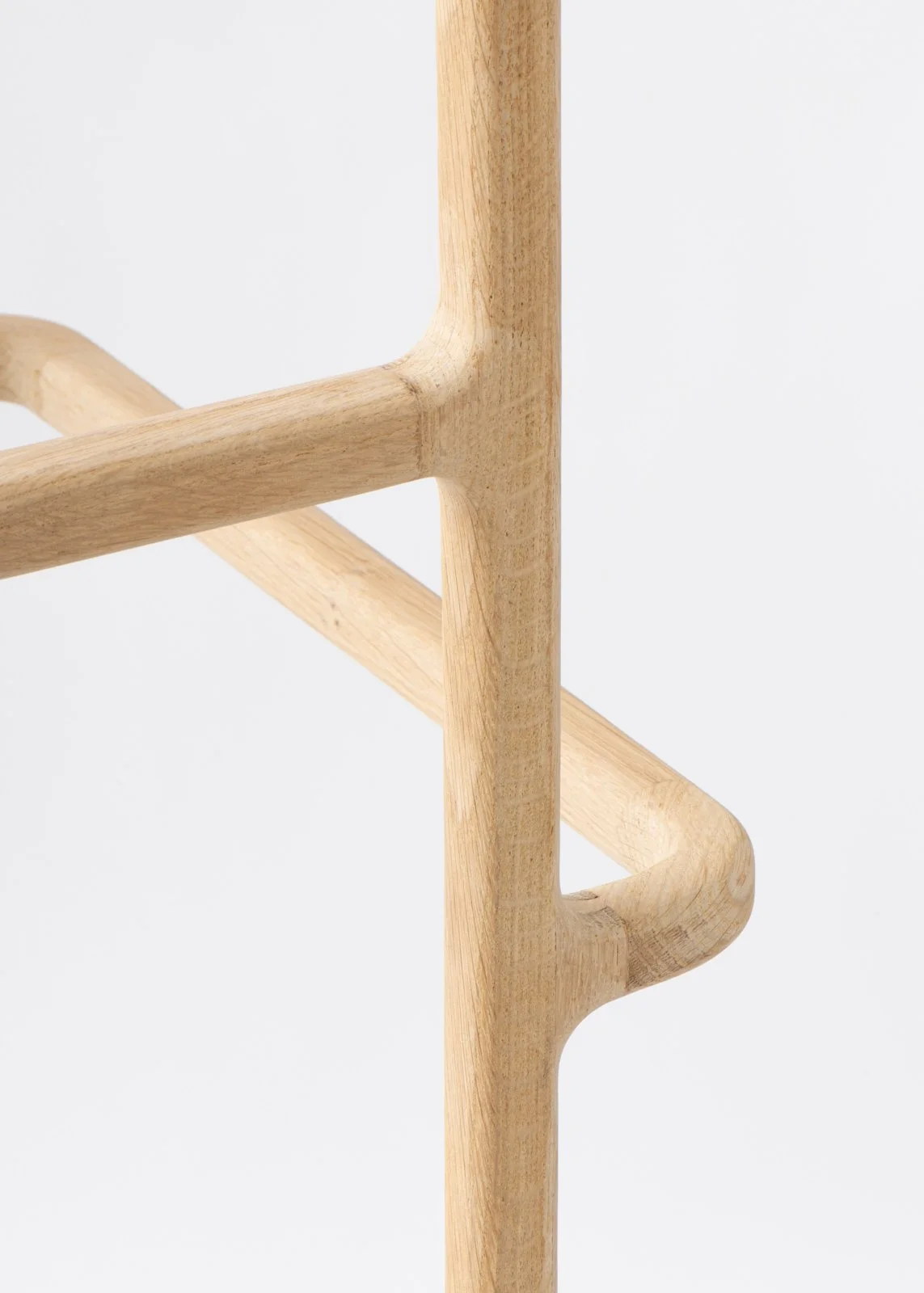 Vue rapprochée d'une lampe sculpturale en bois clair avec un design minimaliste, sous un fond blanc.
