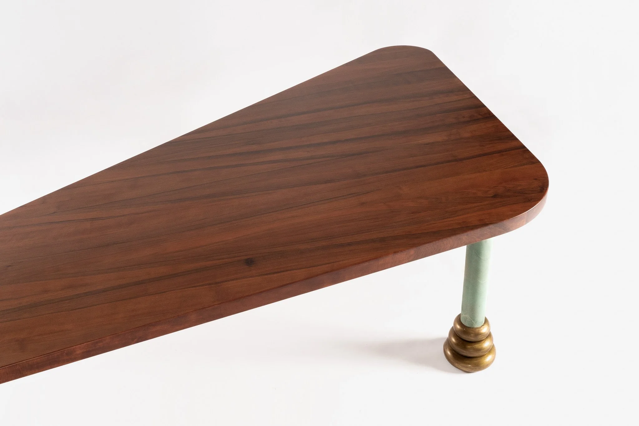 Table en bois avec un plateau rectangulaire en bois foncé et une patte en bois vert avec une base en forme de boule