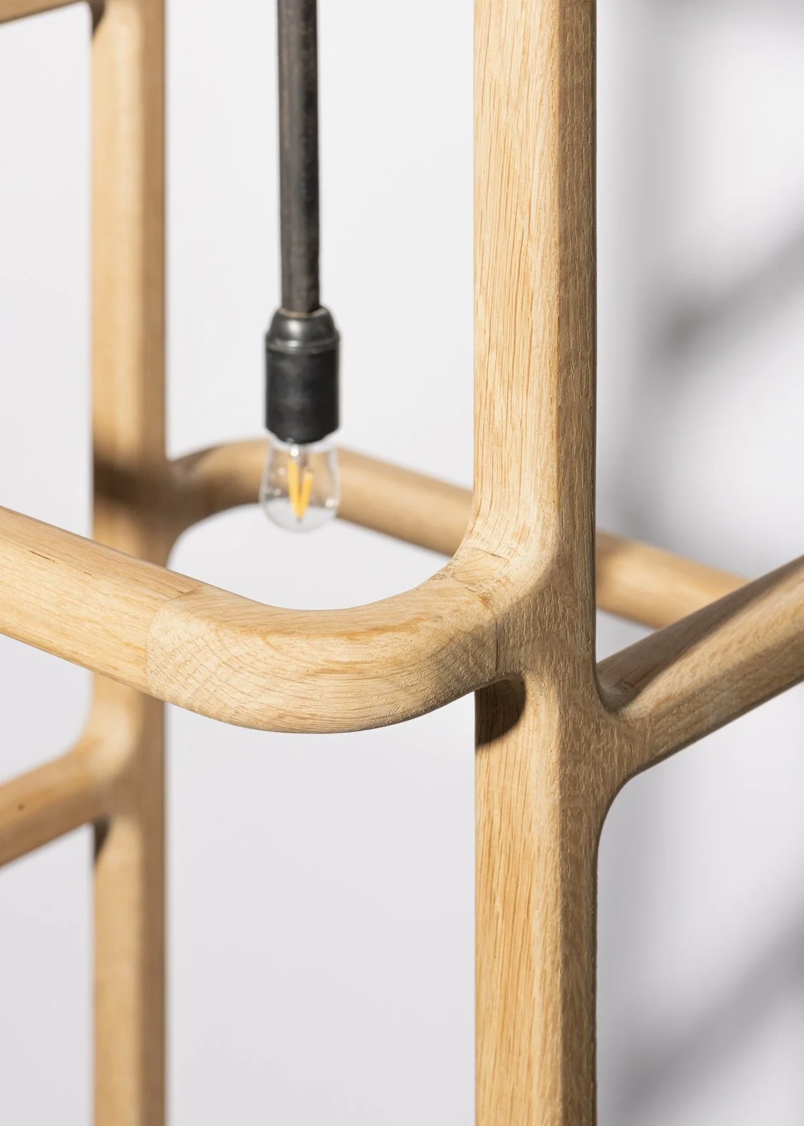Structure en bois avec une ampoule électrique suspendue au centre.
