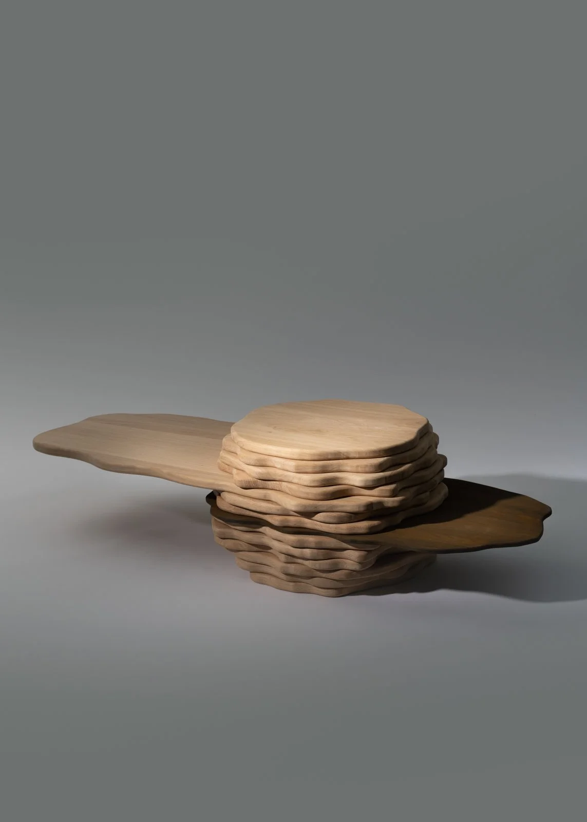 Une pile de planches en bois, certaines larges et autres plus petites, disposées de manière artistique sur un fond gris.