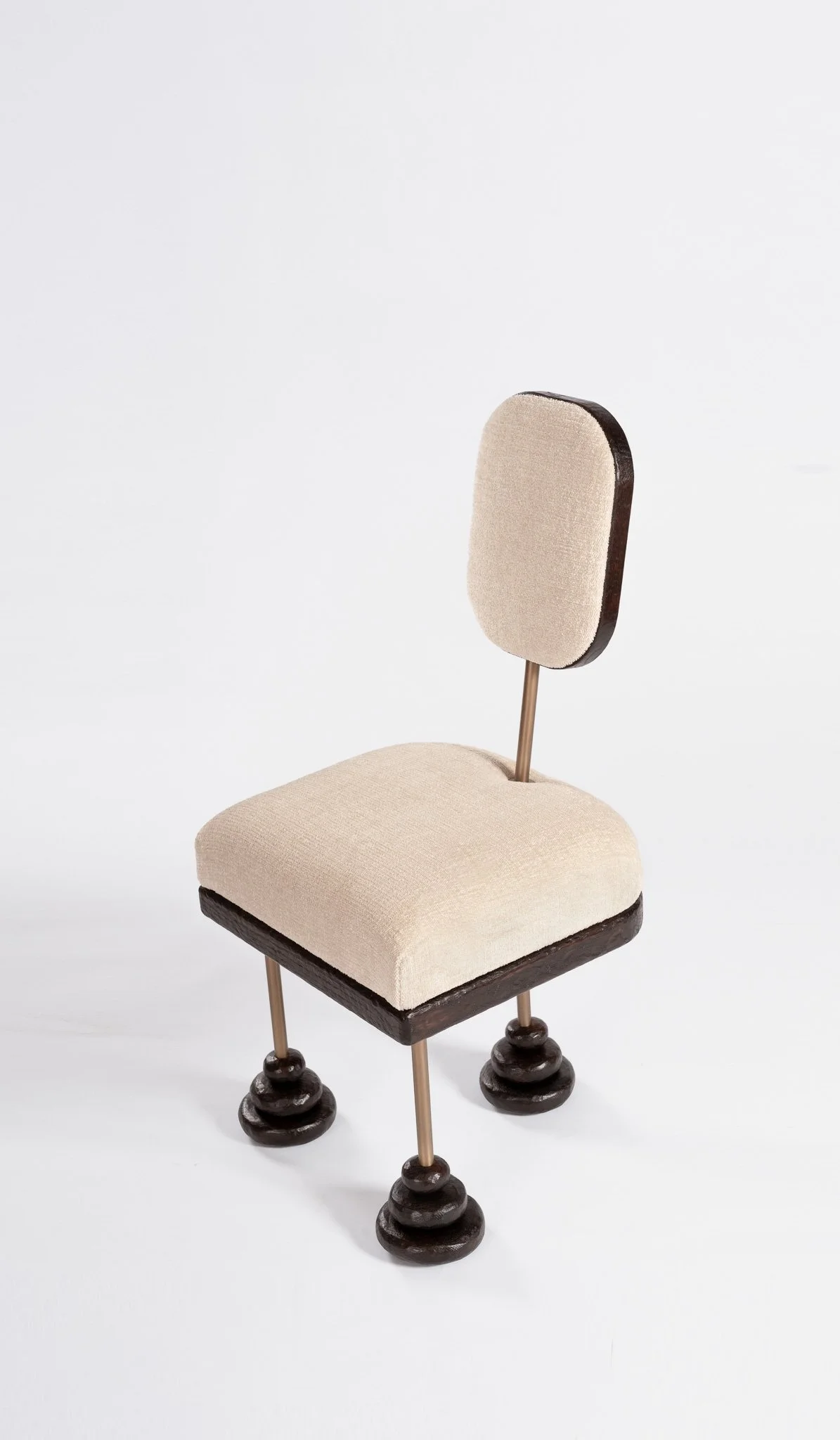 Chaise de designer avec un siège et un dossier rembourrés en tissu beige, quatre pieds en bois tournés.