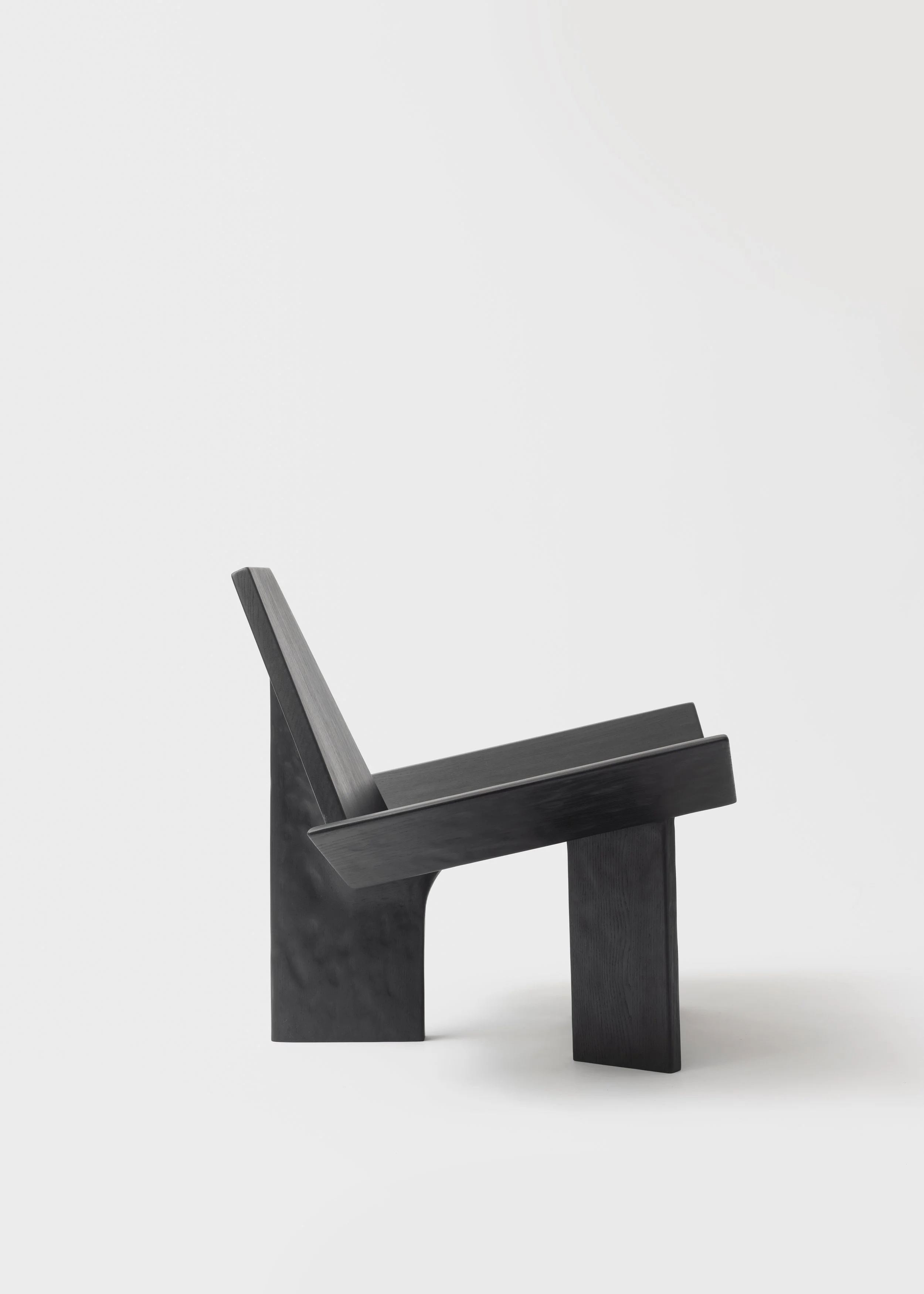 Chaise en bois noire sur fond blanc minimaliste.