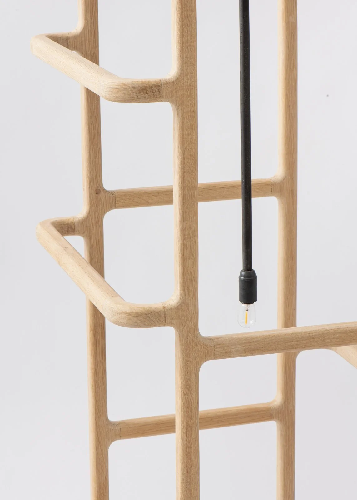 Structure en bois avec un câble noir et une ampoule électrique suspendue