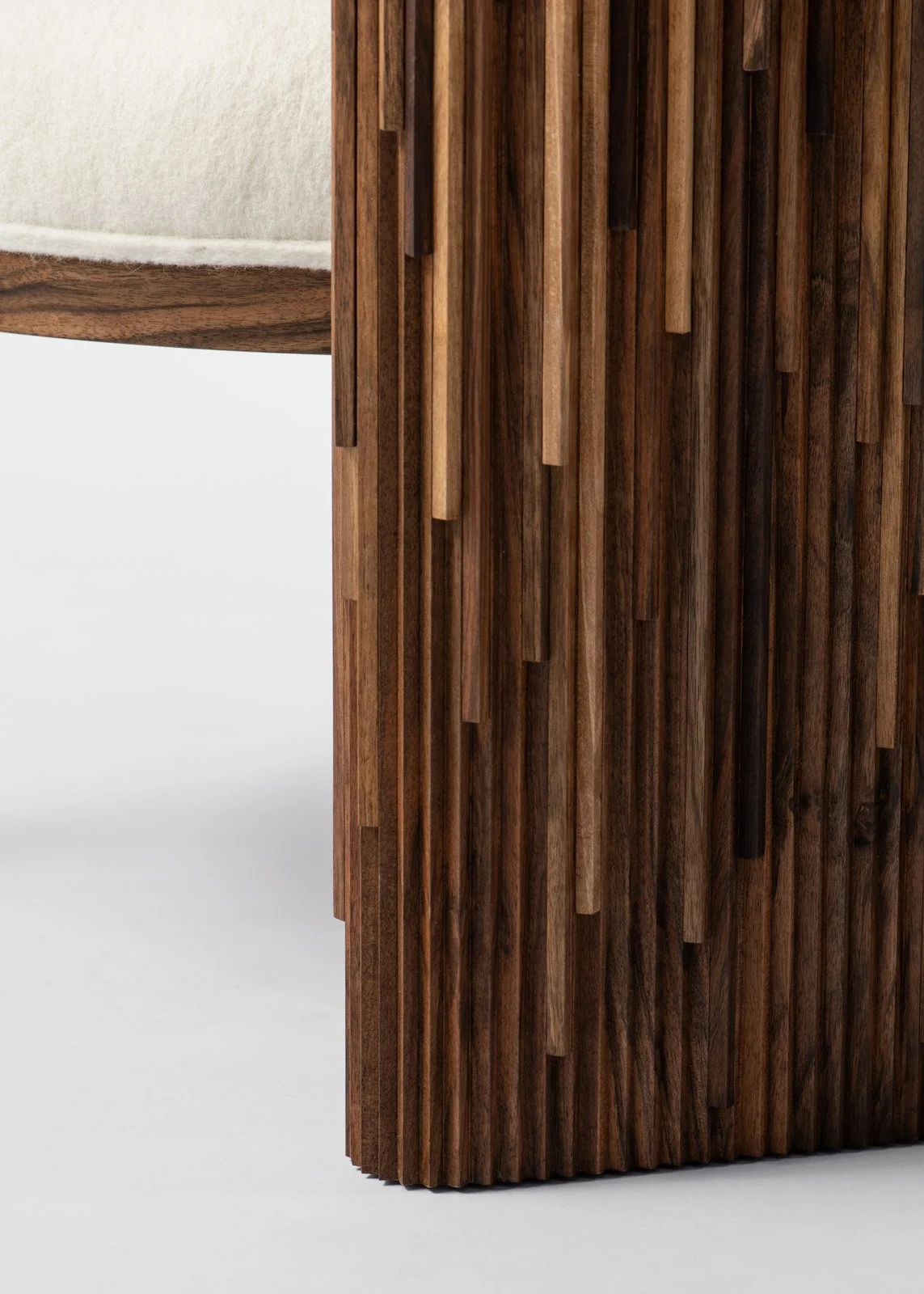 Détails d'une pièce de mobilier en bois sculpté, avec des lames en bois verticales.