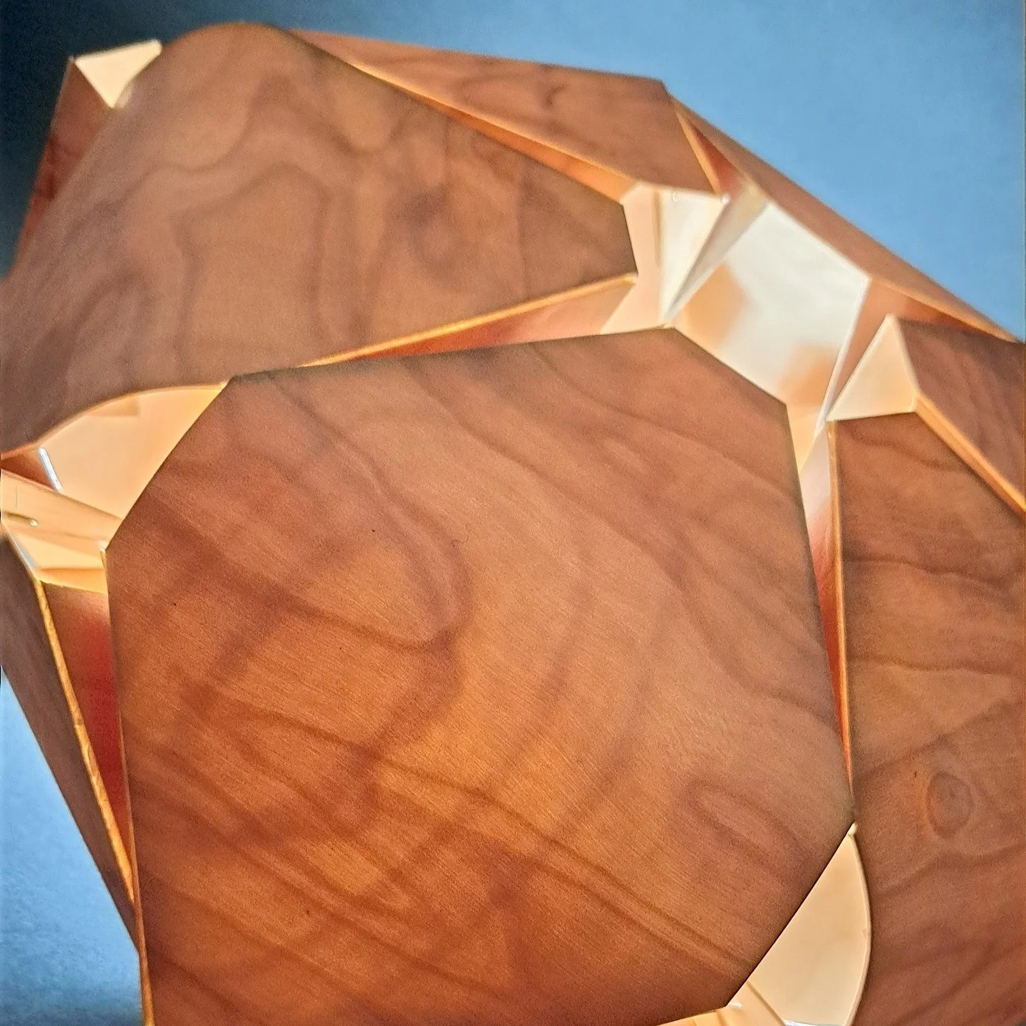 The material that I am working with is tri-ply, which lends it to a new techniques that I have developed. By laser cutting through just the top layer of veneer it is possible to steam and bend the material along the score line. This lampshade has bee