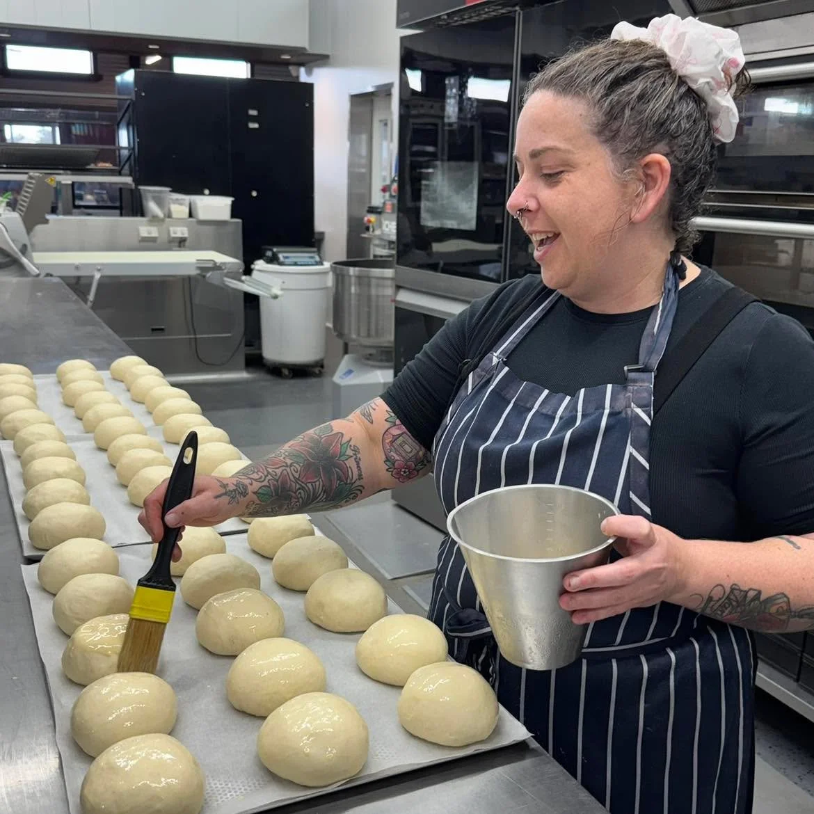 Executive chef Jemmah in our bakery, lending a helping hand to our bakery team. Our bakery makes a multitude of different bread from scratch in-house, daily. Servicing the cafe, these include the milk buns for burgers, the baguettes used for the roll