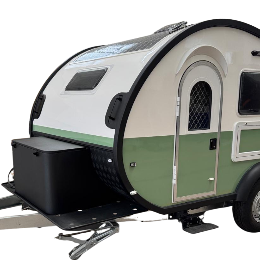 A small, modern teardrop shaped travel trailer with a white and green exterior, featuring a rounded shape, a small door, a window, and a storage box attached to the front hitch.