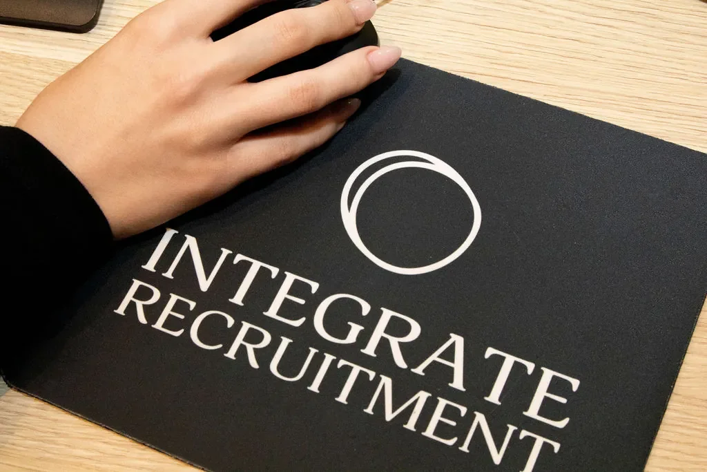 Close-up of Integrate Recruitment branded mouse pad on a desk in the Melbourne office.