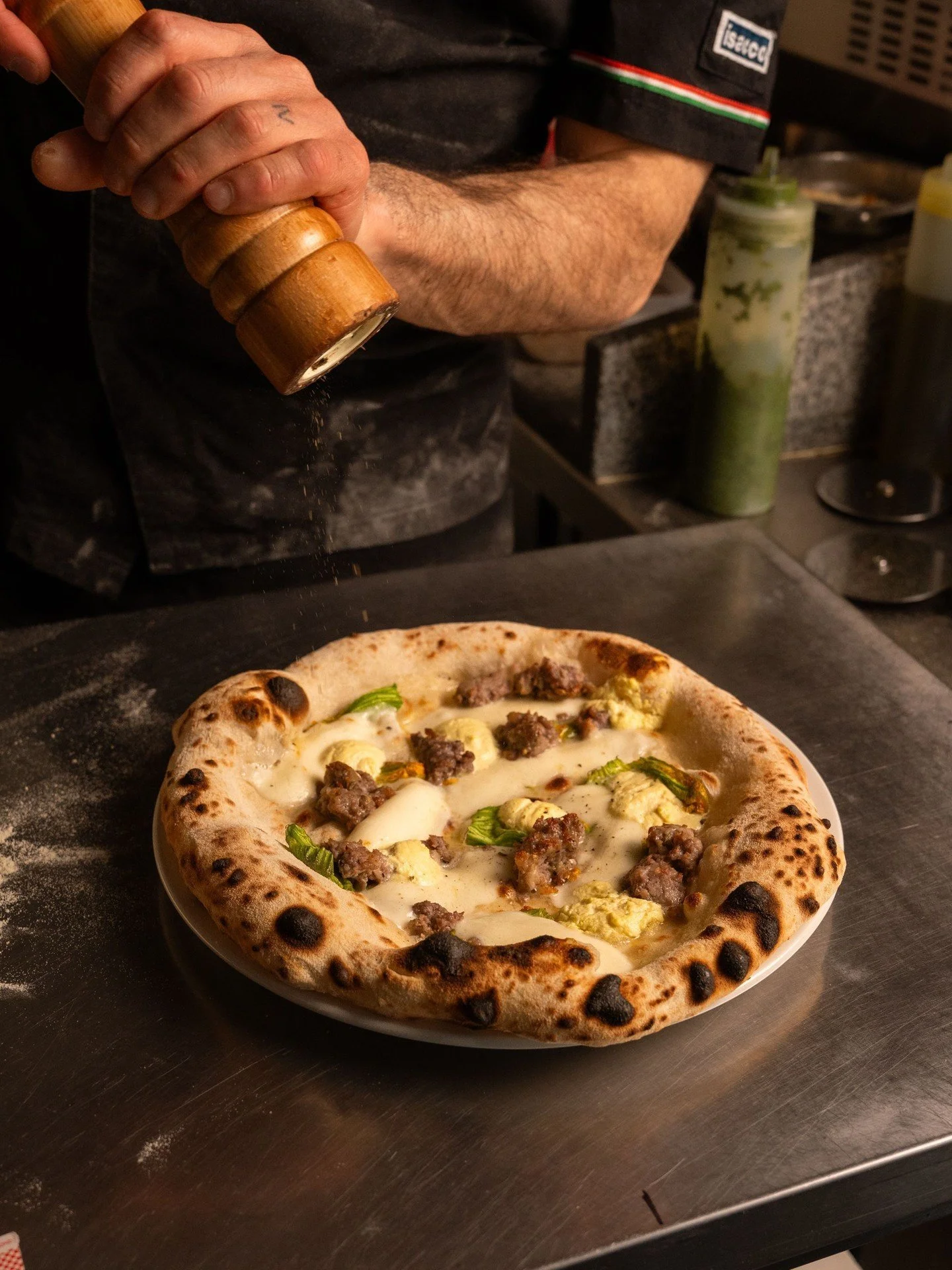 Pizza of the month

Salsiccia, ricotta e fiori di zucca

Built on Fior di Latte di Agerola, topped with homemade Italian sausage with fennel, saffron buffalo ricotta, and courgette blossom. Rich, slightly sweet, and balanced with a delicate floral no