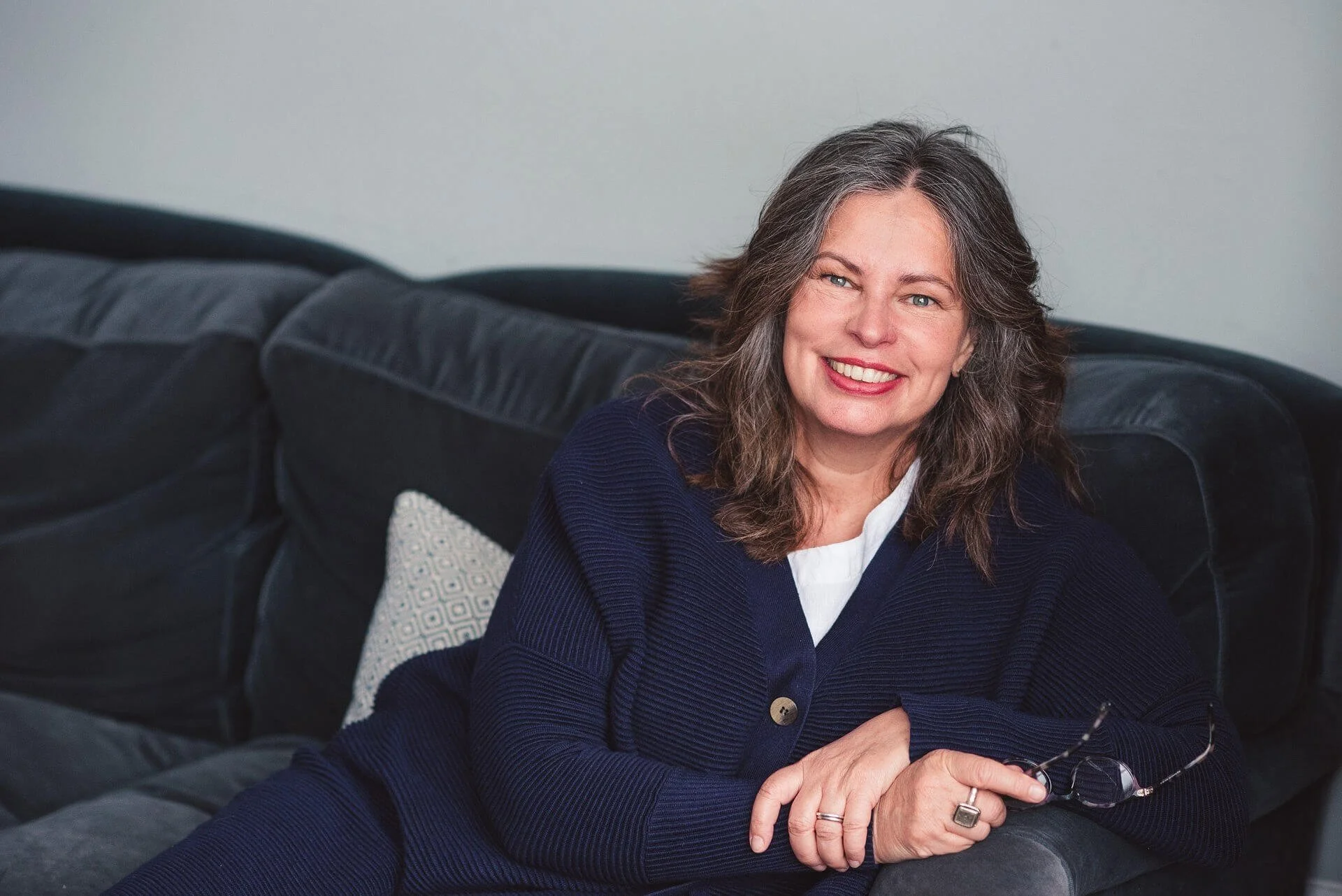 Jane Willis sitting on a sofa, smiling into the camera