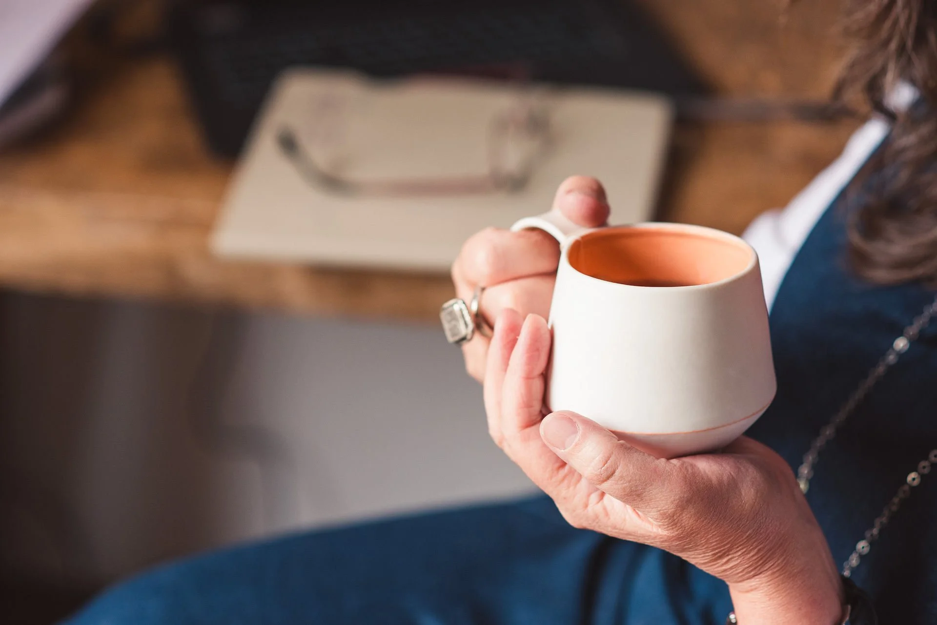 Jane Willis's hands holding a cup of tea in a coaching session
