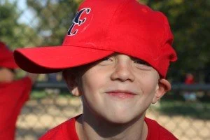 Child wearing red baseball cap