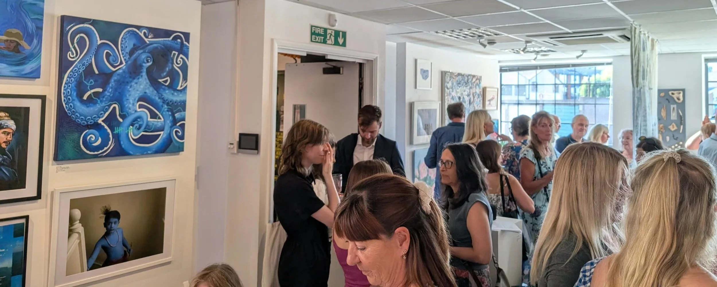 Crowd of visitors viewing artwork at the opening night of the Out of the Blue art exhibition at New House Art Space in Guildford, Surrey.