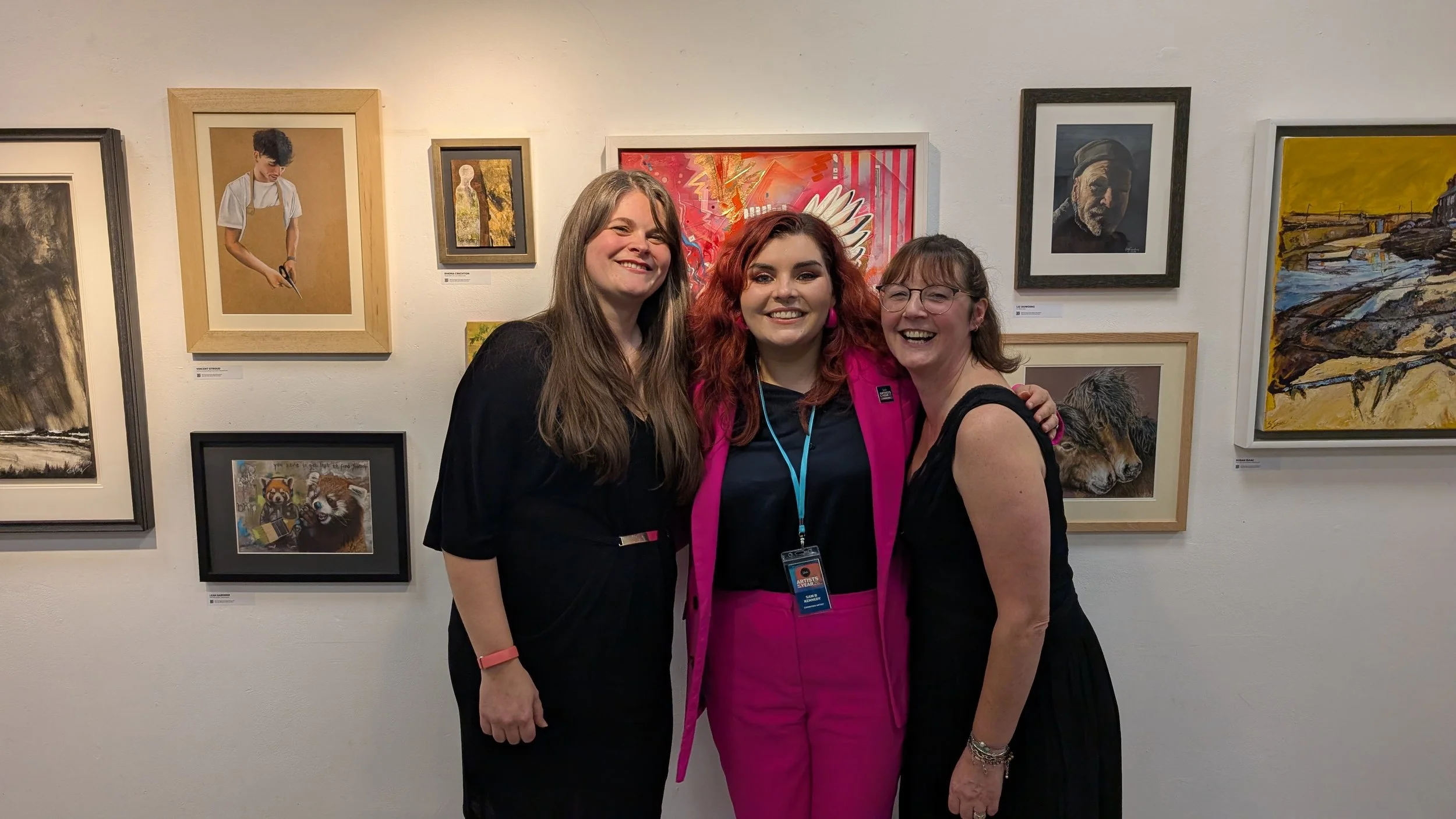 Artist Sam B. Kennedy celebrating her selection for the SAA Artist of the Year 2026 finals alongside SAA team members Tara Paul and Chrissy McFadyen at the Cass Art Kingston exhibition.
