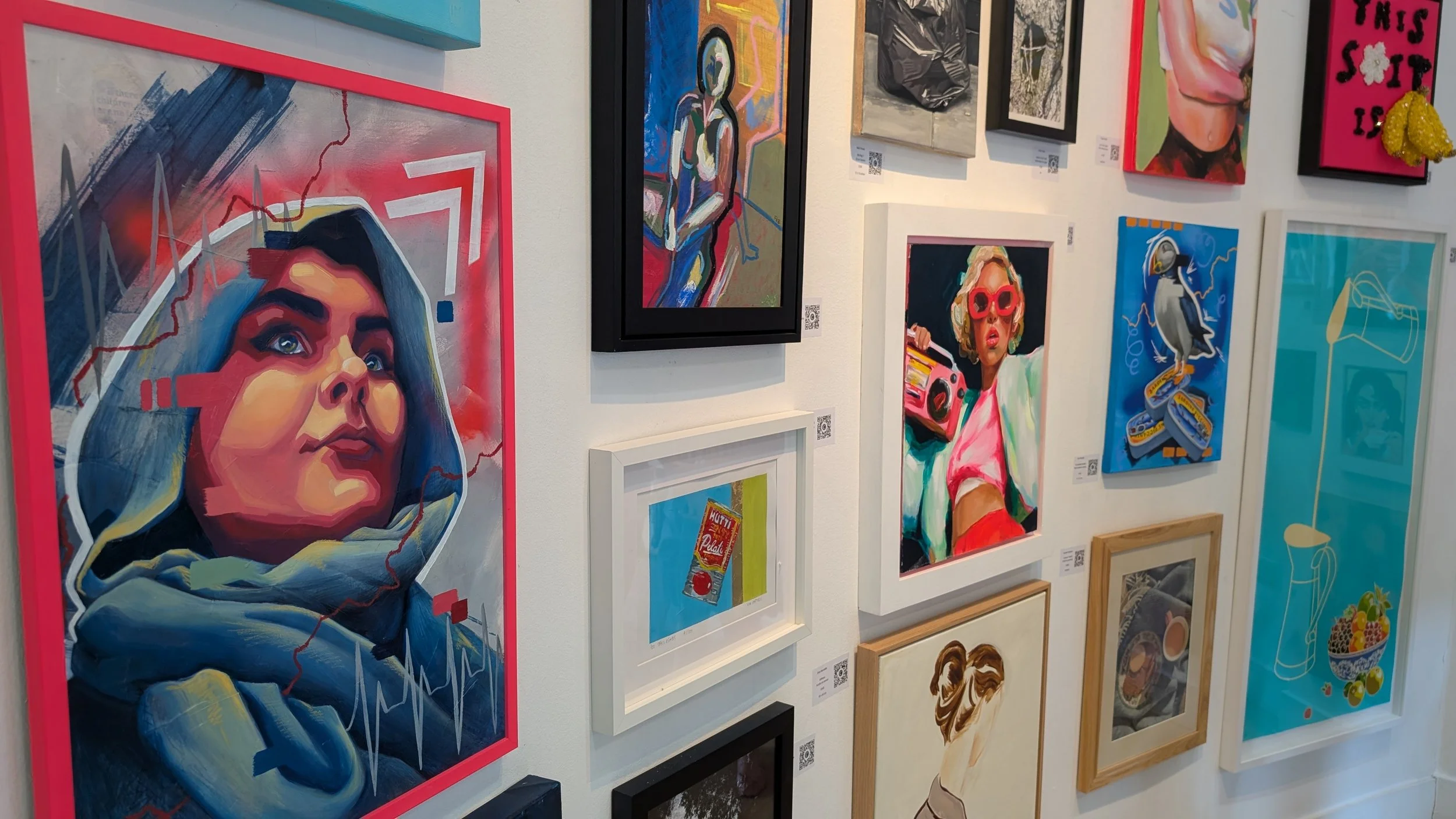 Gallery wall at The Gallery at the Playroom in Archway, London, featuring vibrant mixed media artworks by emerging artist Sam B. Kennedy alongside other contemporary artists in the Everyday Magic exhibition.