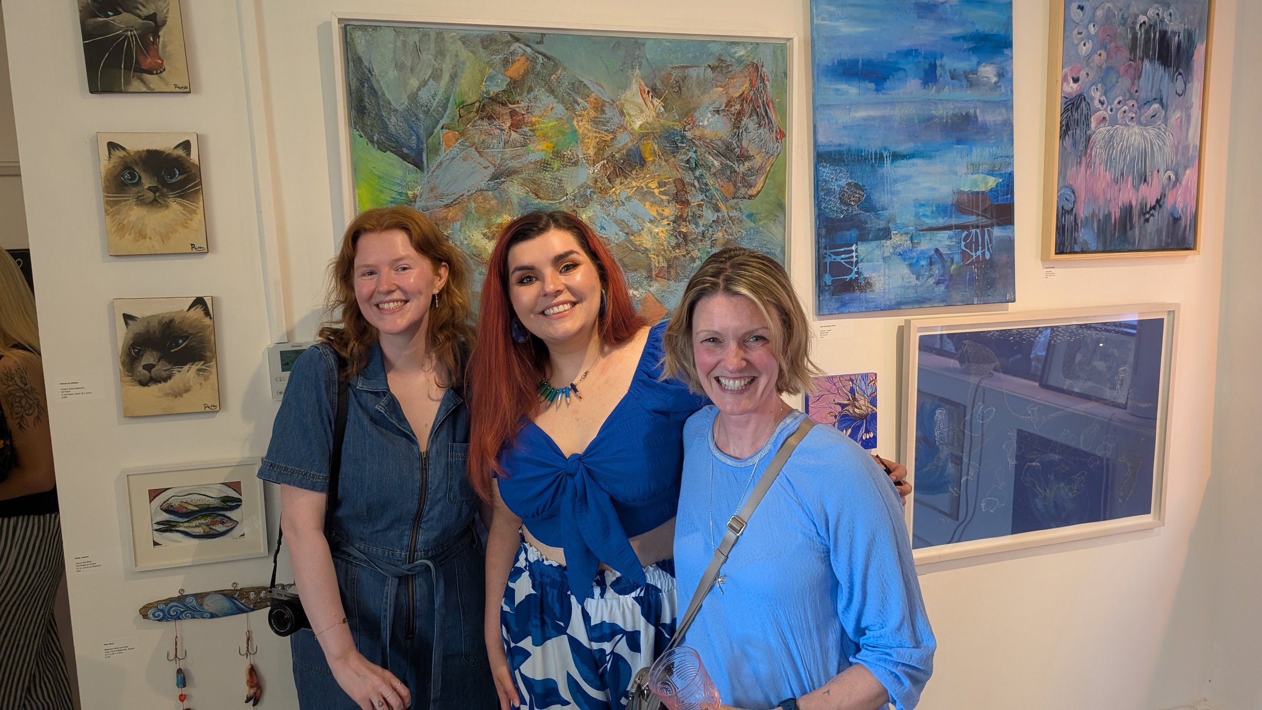 Guildford artist Sam B. Kennedy posing with fellow artists at New House Art Space during the opening of the Out of the Blue art exhibition in Surrey.