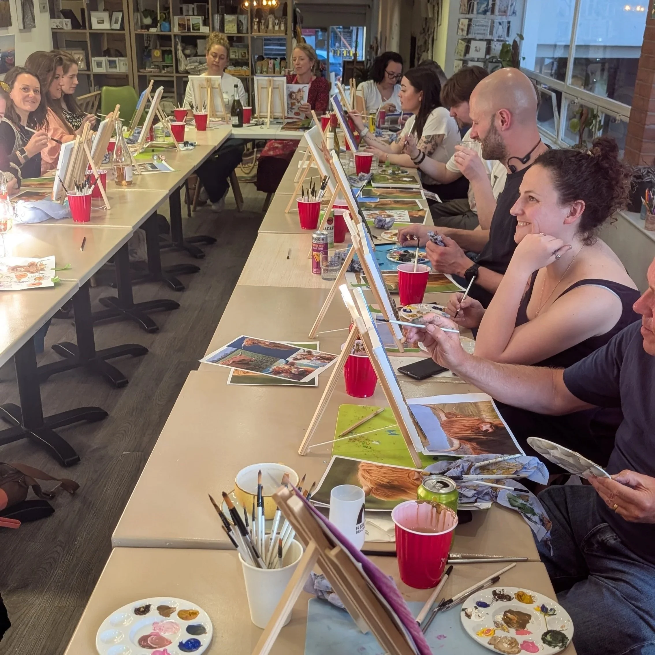 Participants enjoying a relaxed acrylic painting workshop in Guildford, following step-by-step guidance from artist Sam B. Kennedy during a sold-out Paint & Sip event at Art & Grind in Surrey.