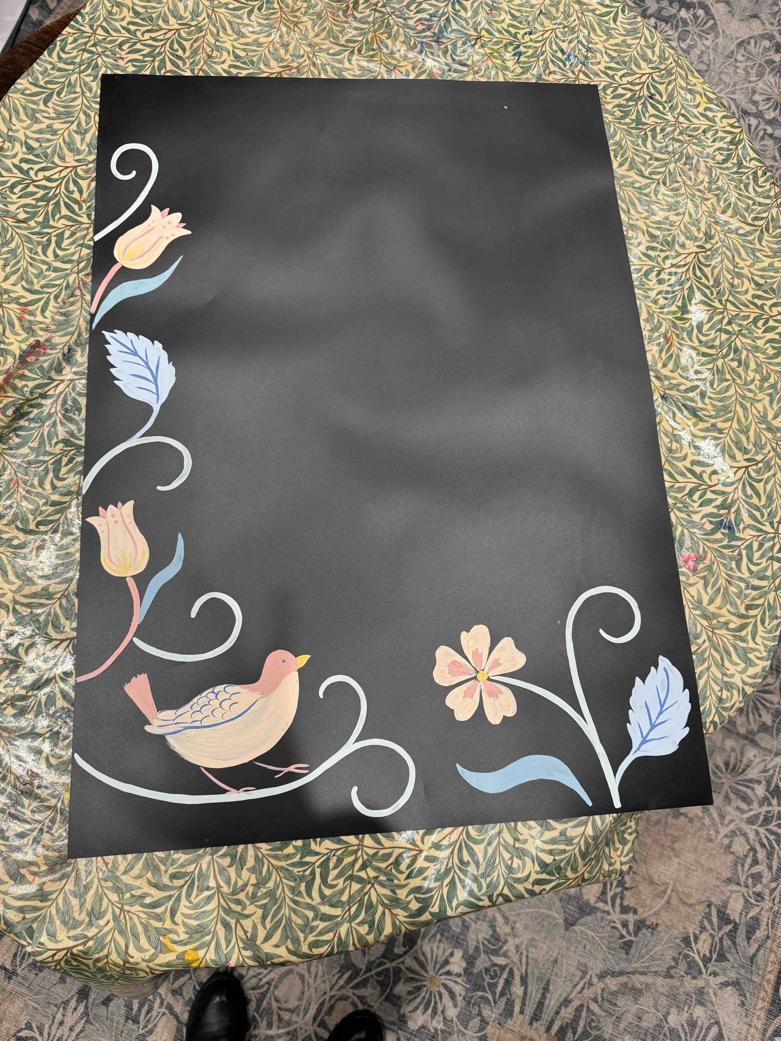 Photo of a hand-painted chalkboard decorated with birds, leaves and flowers