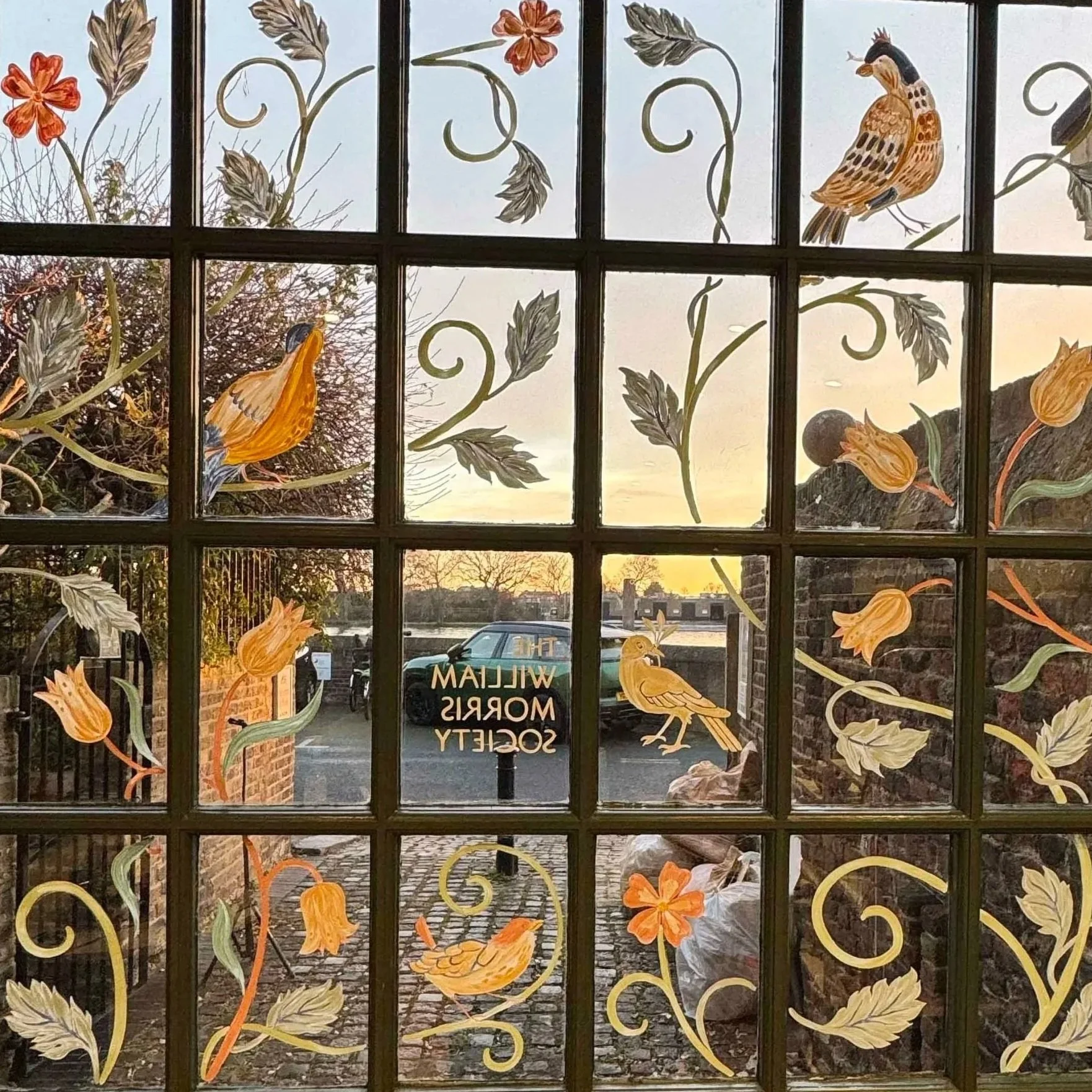 Window art at William Morris Society, viewed from the inside at dusk