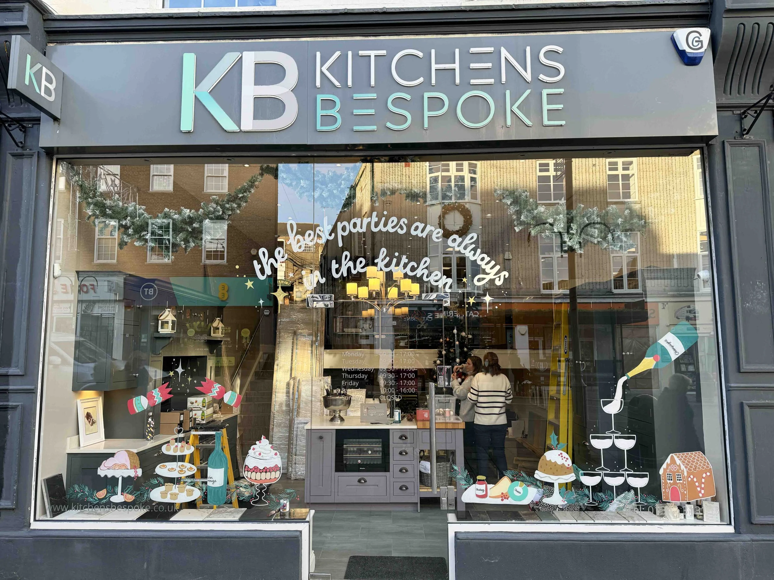 Window mural featuring delicious Christmas foods and the message: the best parties are always in the kitchen