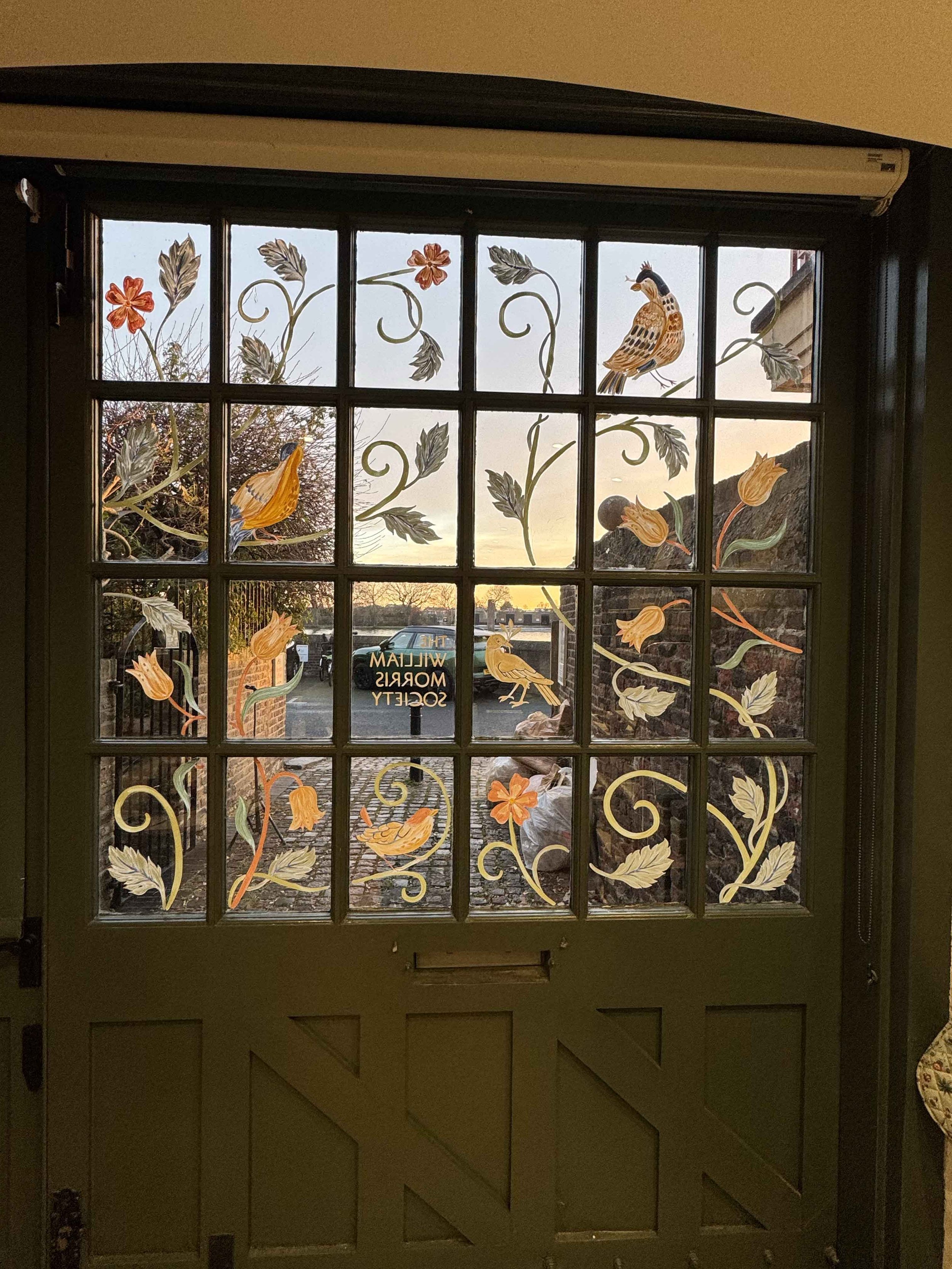 Window mural as viewed from the inside at dusk with the sunset in the background