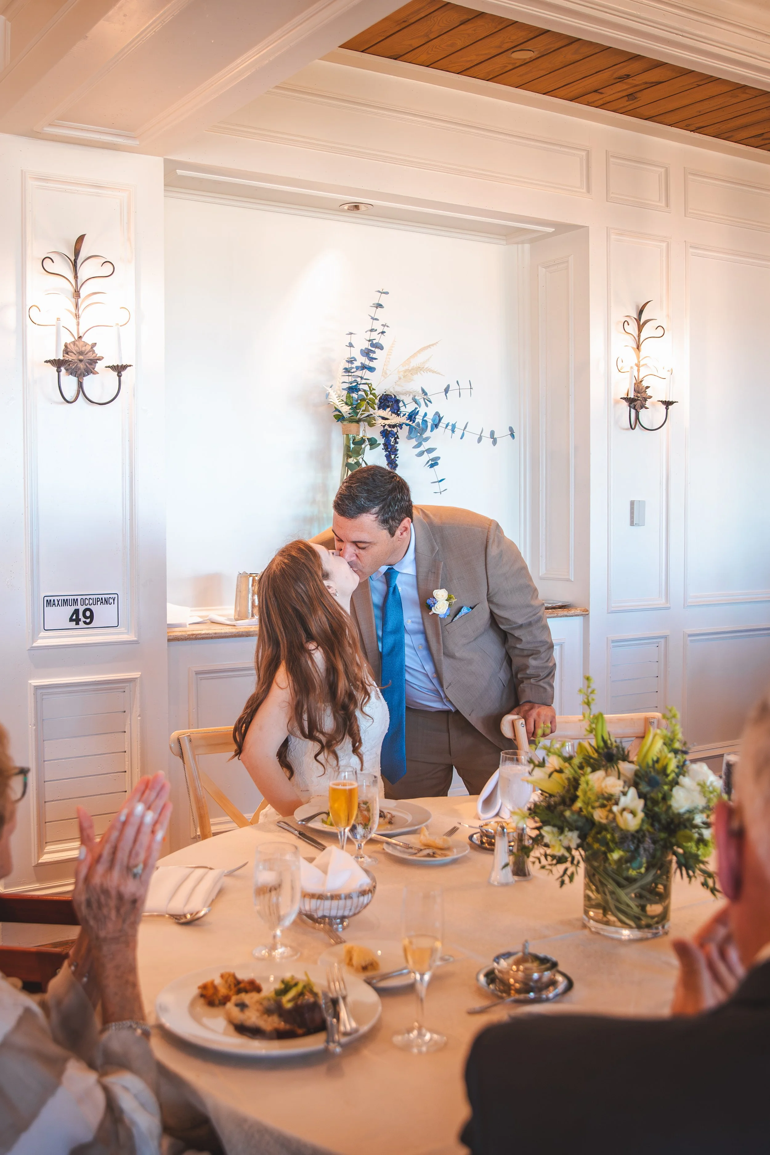 Bride and groom sharing a kiss during their intimate Ritz-Carlton Sarasota wedding luncheon