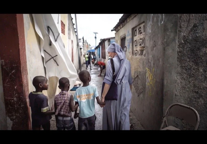 woman walking down alley with children