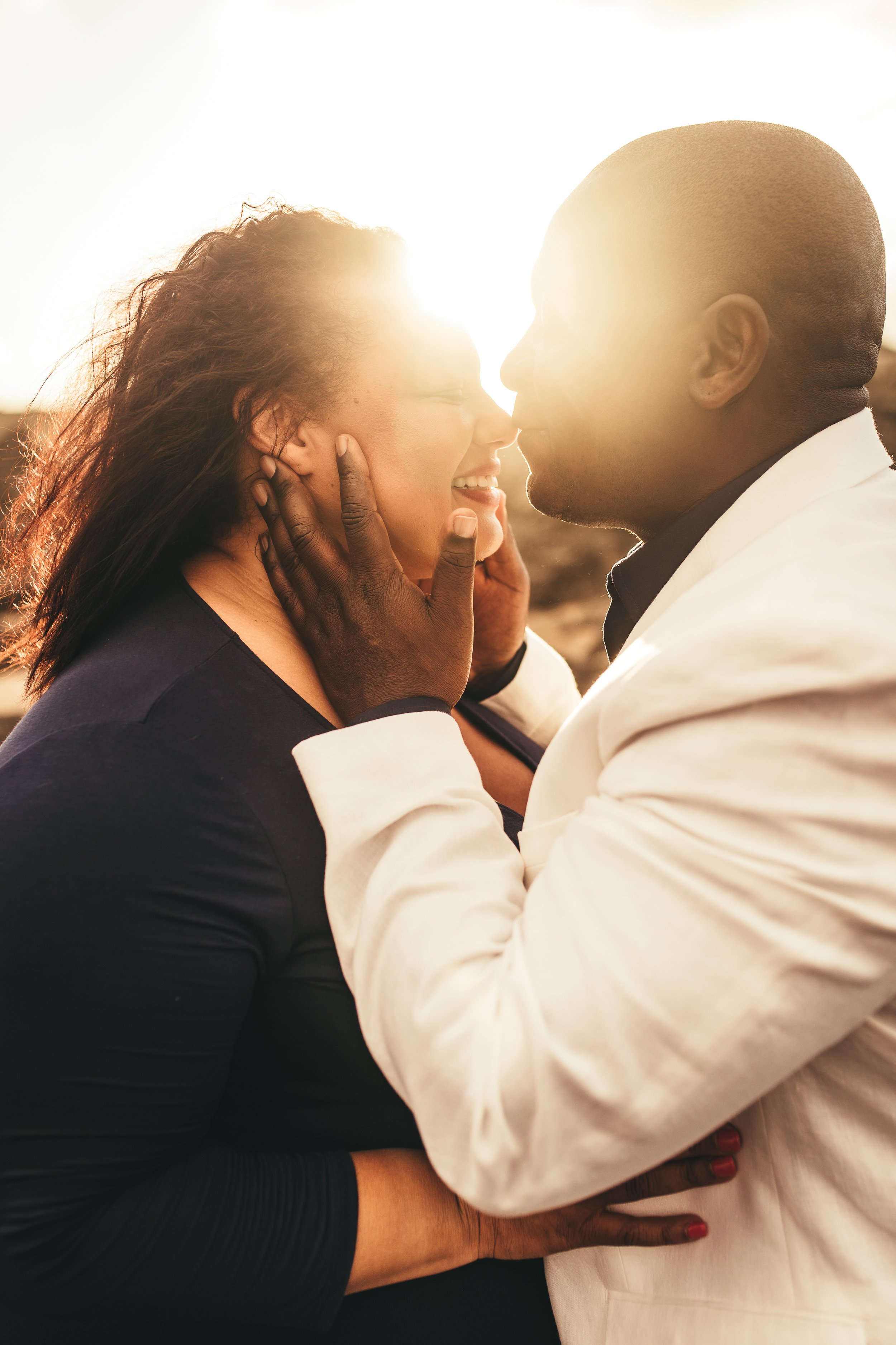 african amercian man and woman embracing each other while man kisses her nose in maui hawaii