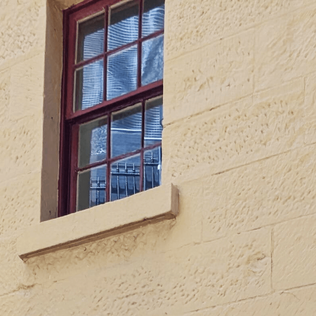 a close up photo of the painted exterior facade of a historic terrace at 29-31 george street the rocks prior to paint removal