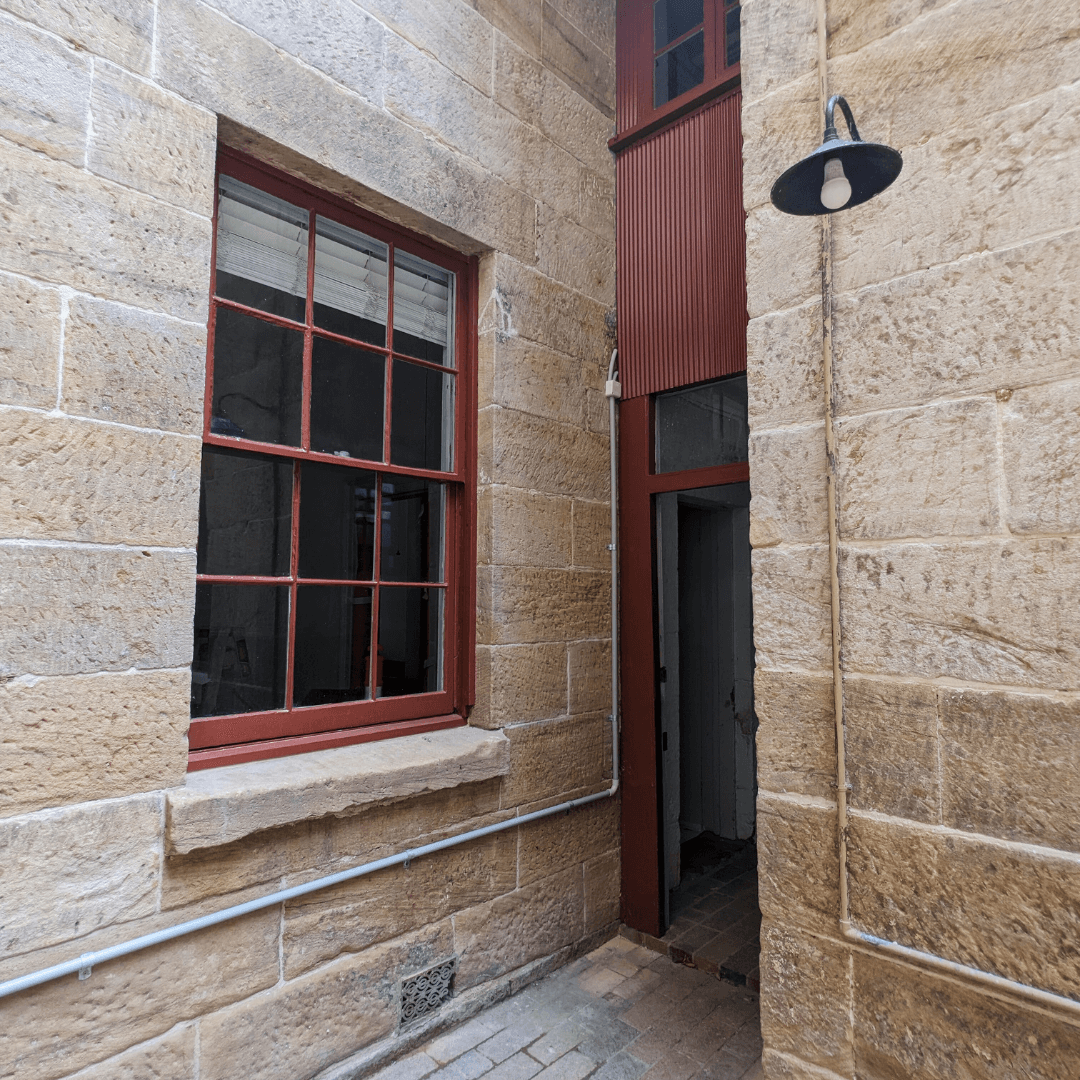 a photo of the exterior facade of a victorian terrace at 29-31 george street the rocks showing the original stonework of the terrace after paint removal