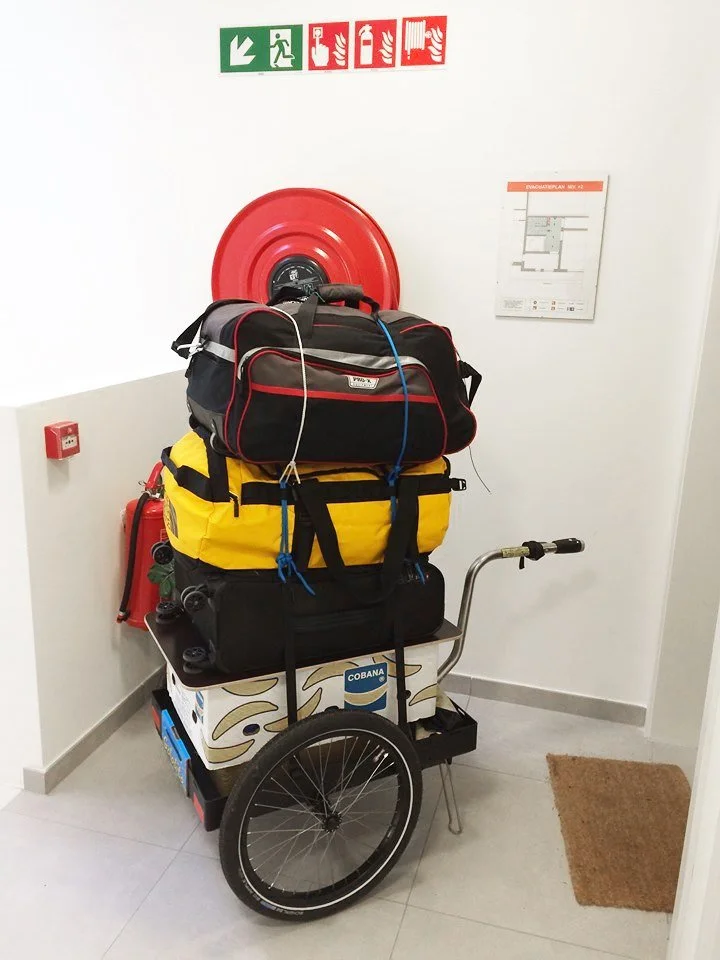Hinterher Hmax mit Reisegepäck als Handwagen am Bahnhof