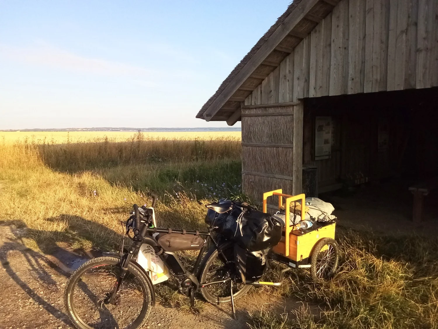 E-Bike mit Hinterher Hmax vor einer Holzhütte am Meer