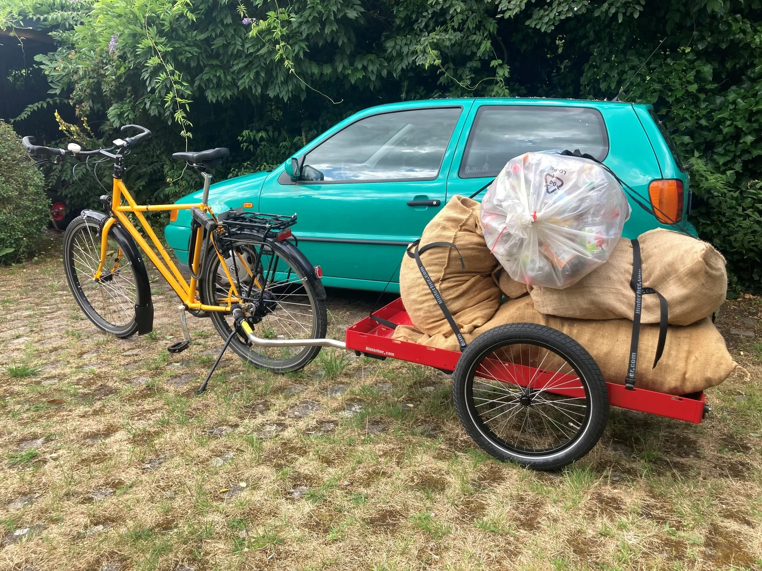 Roter Hinterher Hxxxl light mit vollen Säcken neben einem Fahrrad