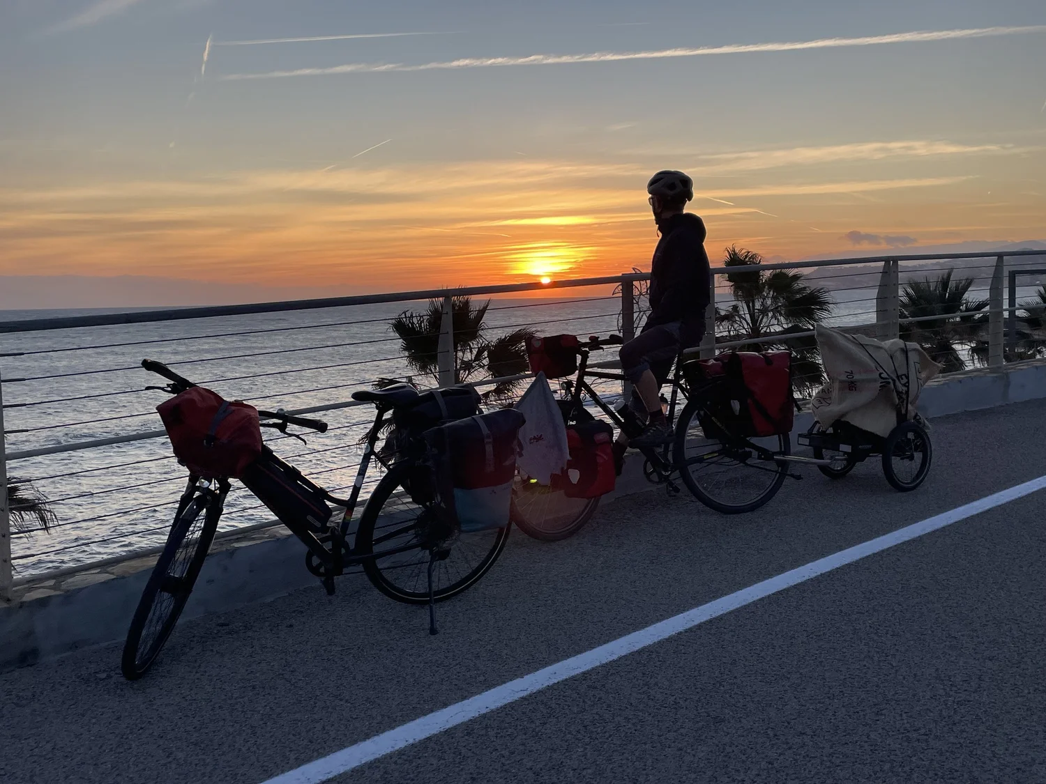 Zwei Falträder mit Hinterher Hmini an einer Strandpromenade im Sonnenuntergang