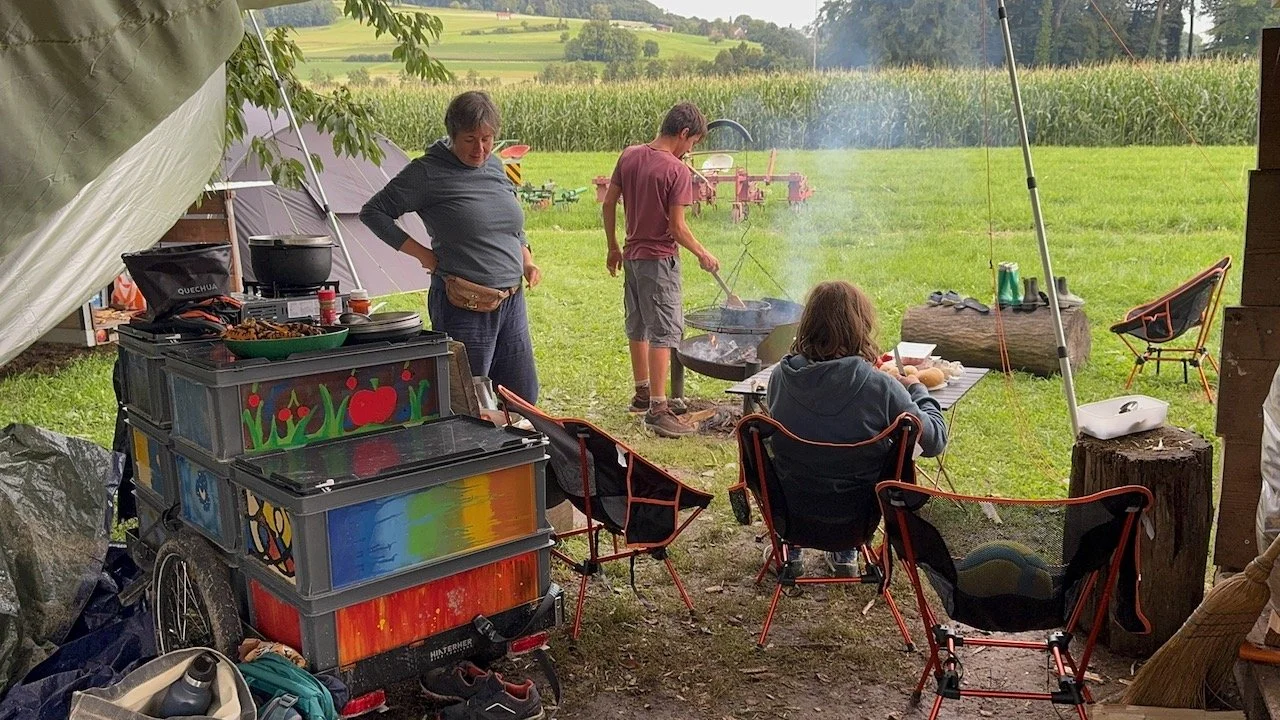 Lagerplatz mit Zelt und bunt bemalten Euroboxen