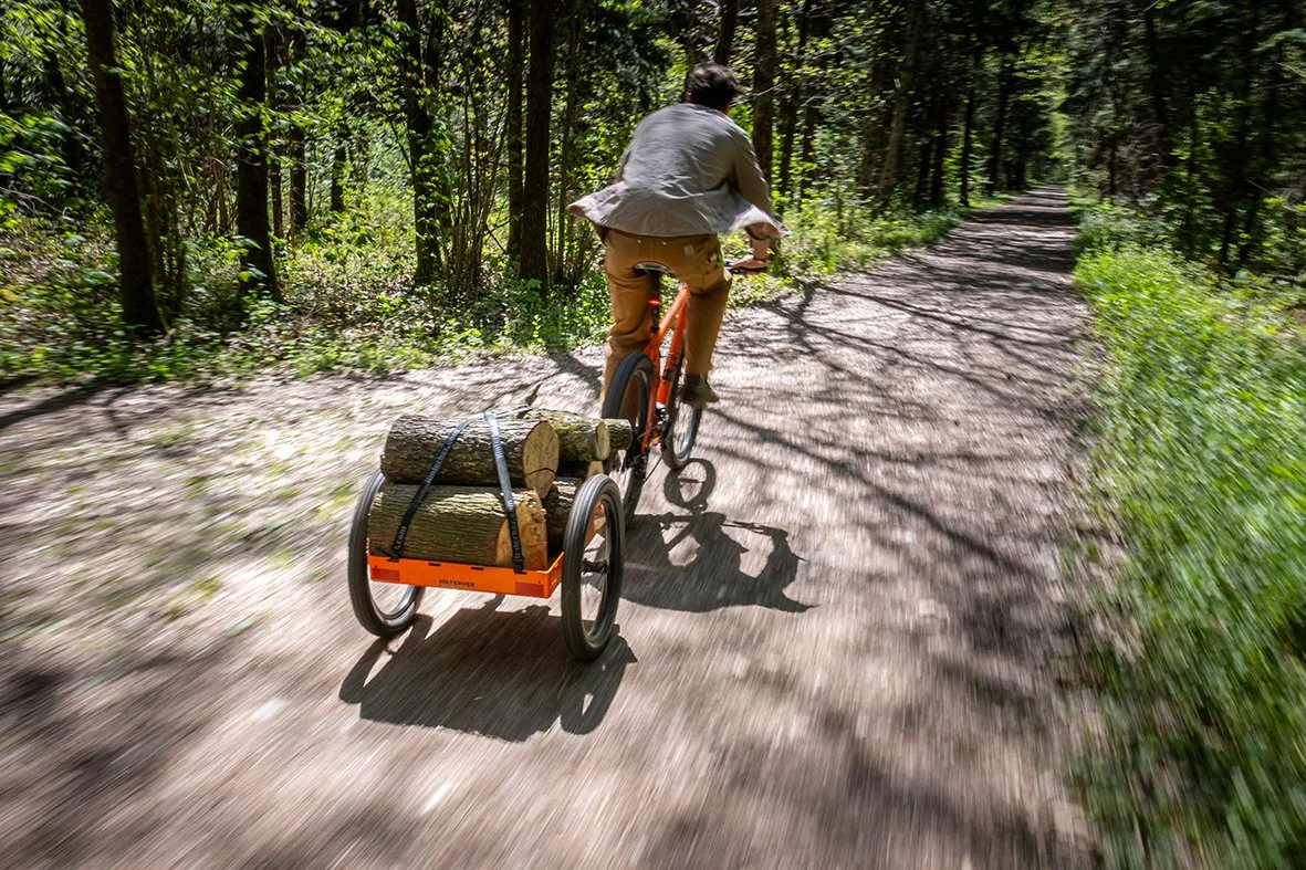 Radfahrer zieht den beladenen Hmax auf einem Waldweg
