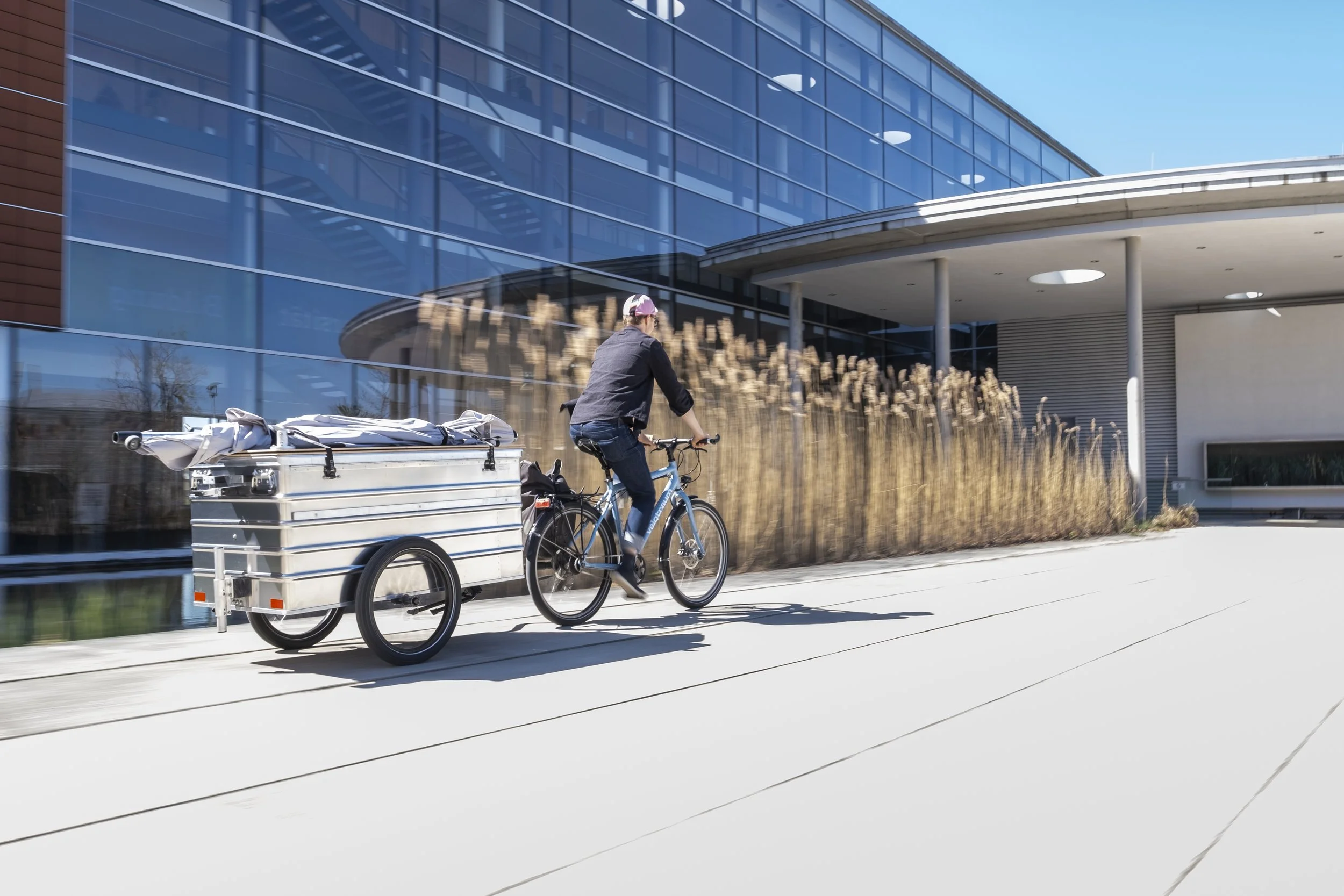 Mobiler Marktstand und Infostand Fahrradanhänger wird mit einem Fahrrad gezogen