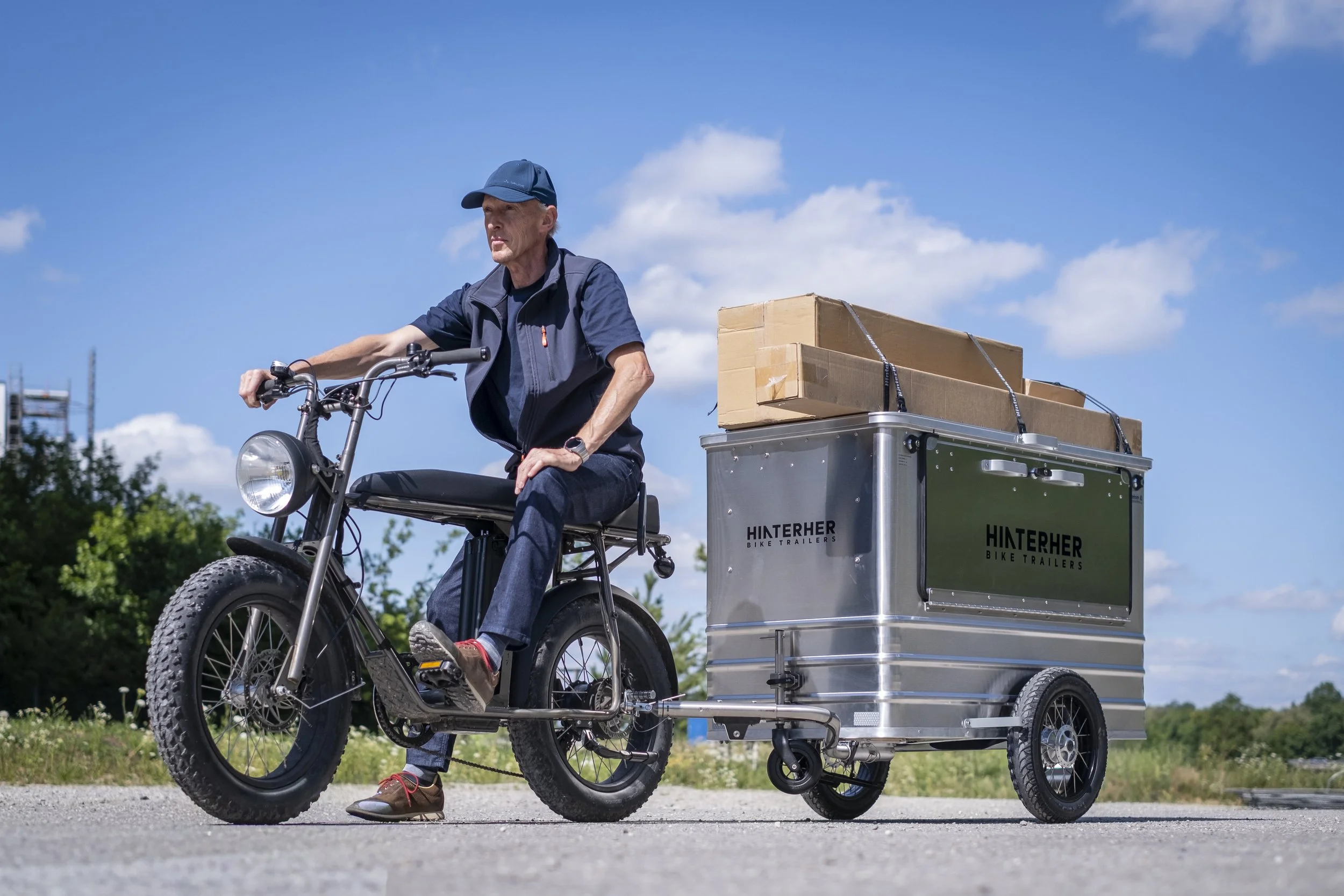 Radfahrer mit Boxenanhänger und Paketen