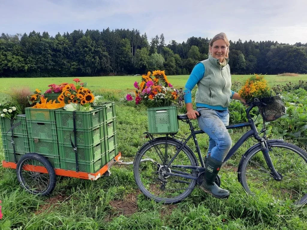 Blumen werden mit dem Fahrradanhänger in Euroboxen transportiert