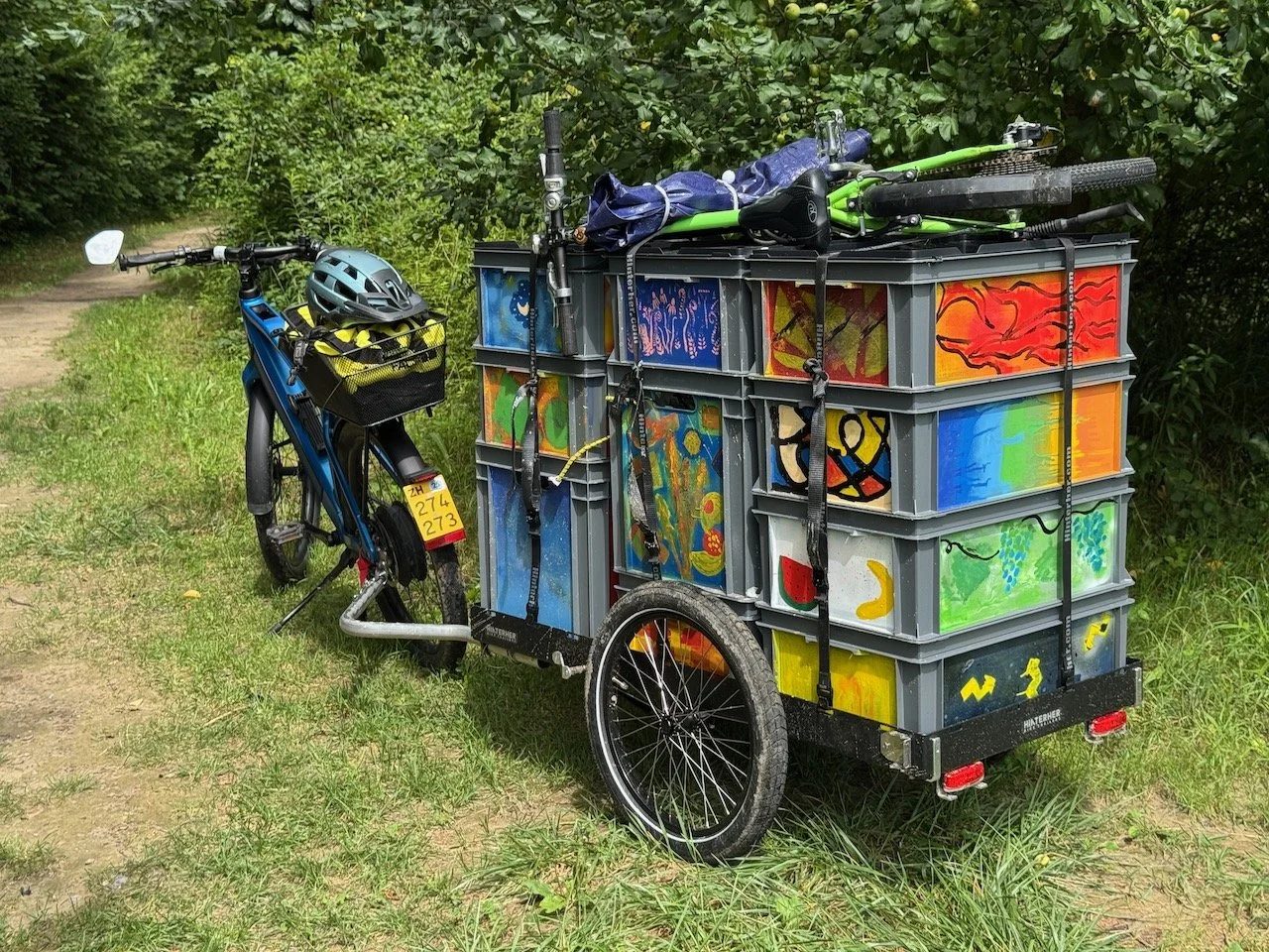 Hinterher Hxxxl light mit bunt bemalten Euroboxen neben einem E-Bike