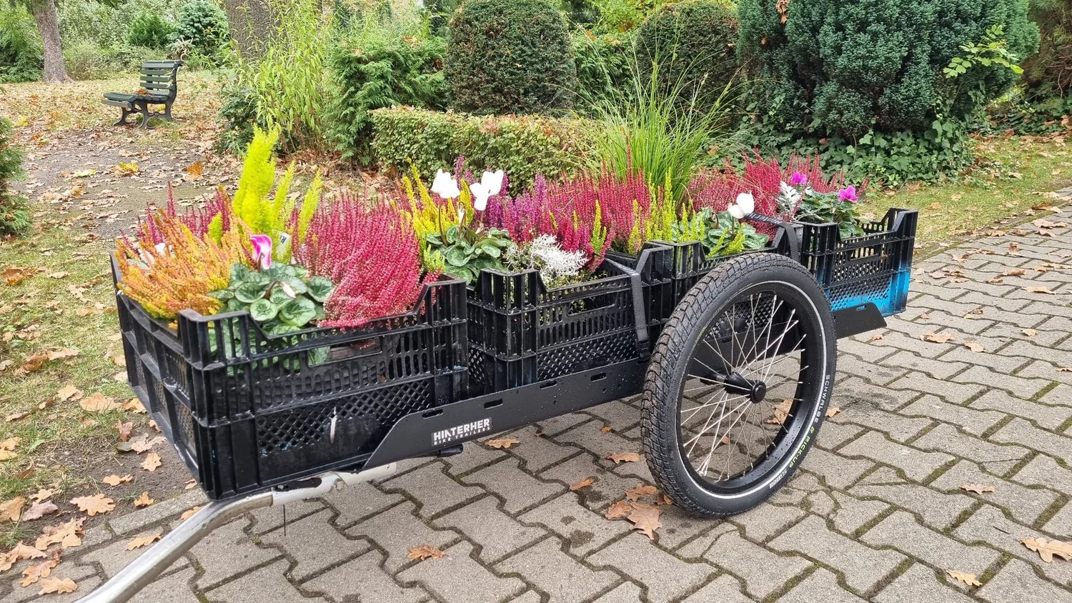 Transporter 1 mit Kisten voller Pflanzen auf einem Friedhofsweg