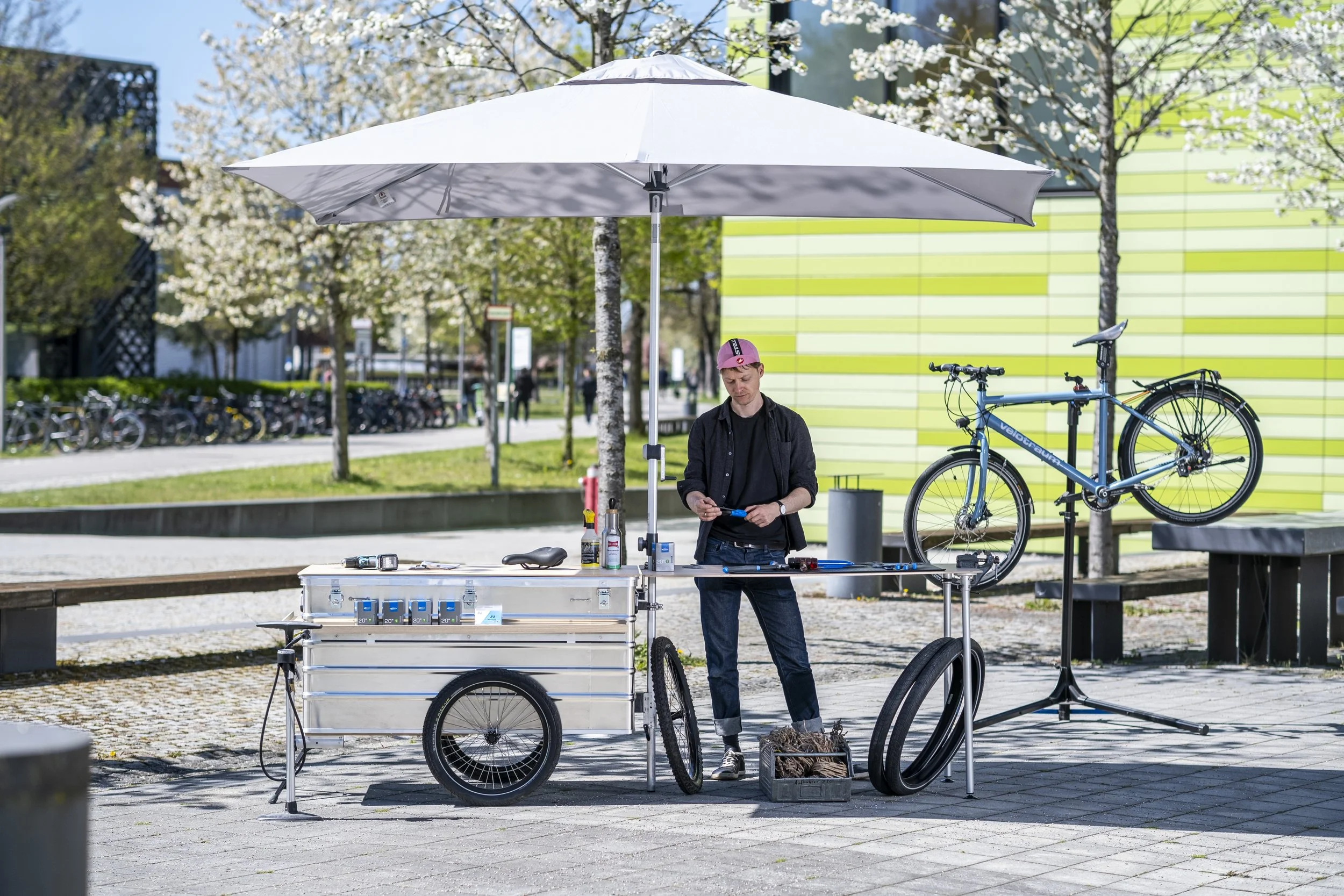 Ein mobiler Infostand Fahrradanhänger mit Schirm und Tischplatte