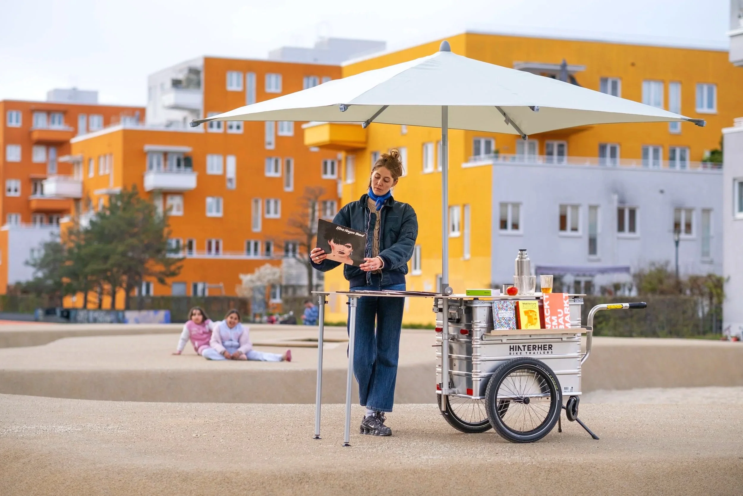 Ein mobiler Infostandanhänger und Marktstandanhänge von Hinterher mit Schirm und Tisch