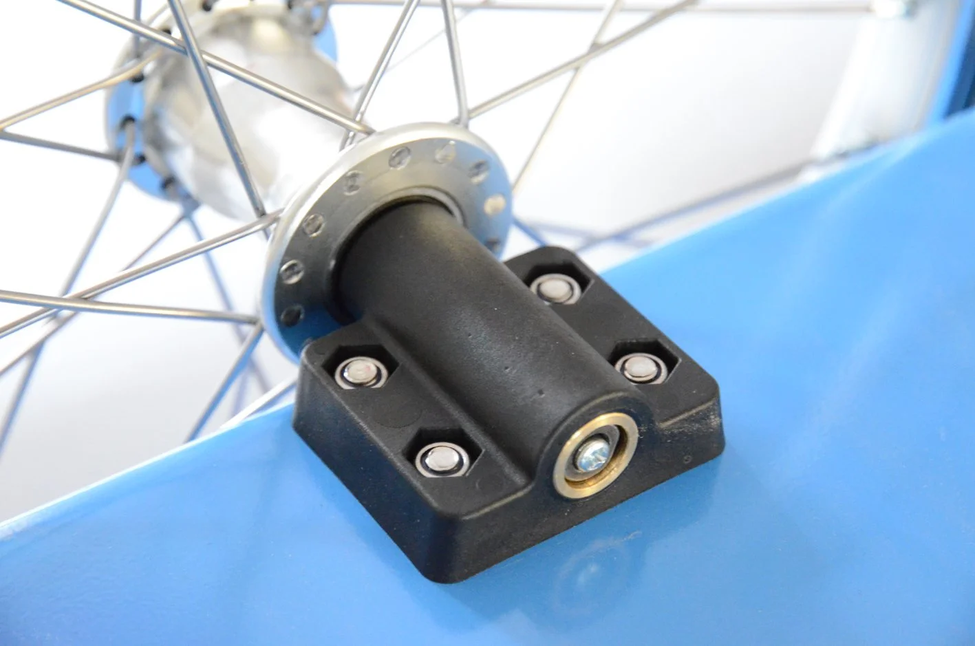 A large plastic axle mount attached to a bicycle trailer for securing the axle