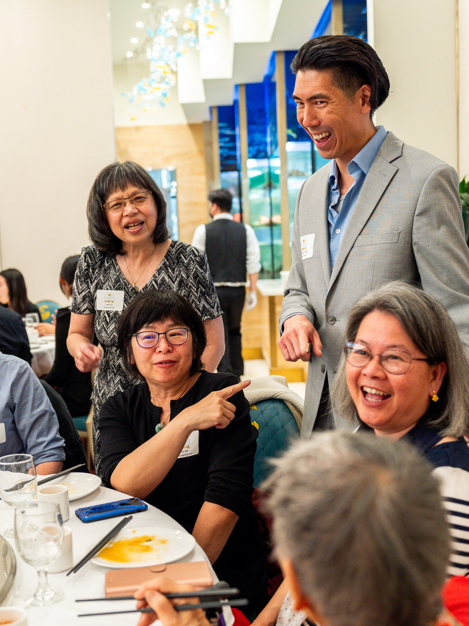 People gathered at a restaurant or banquet, engaging in conversation and enjoying food and drinks.