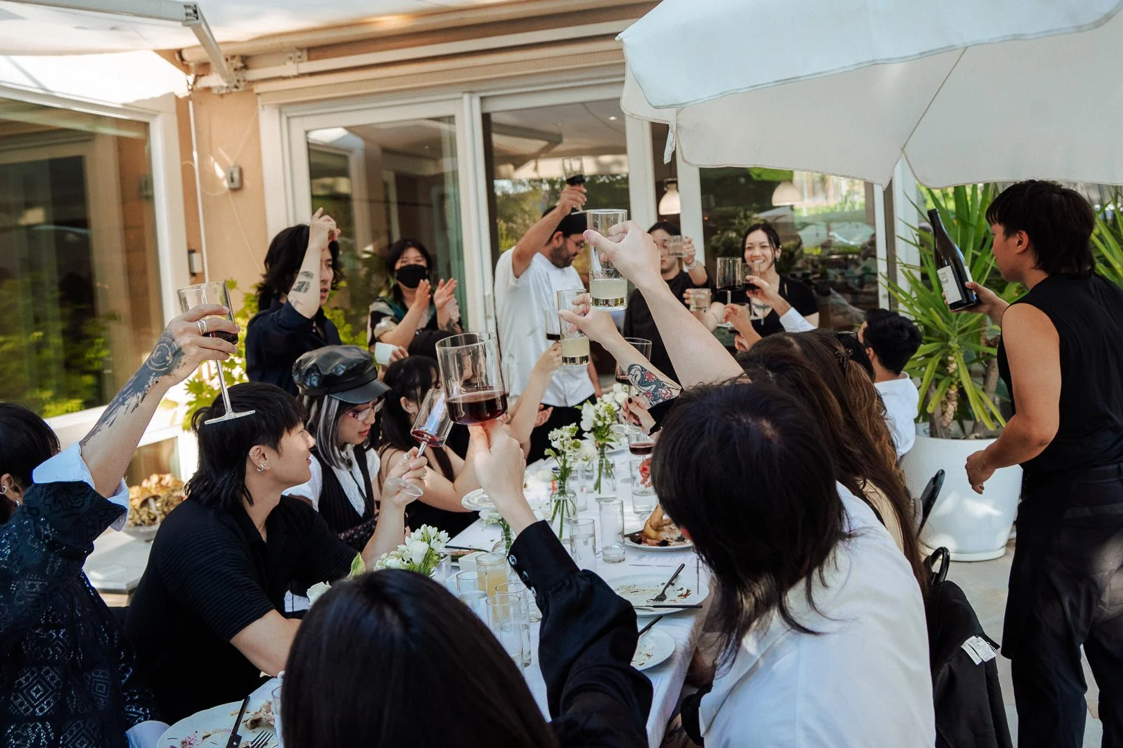 People raising glasses in a toast at an outdoor gathering