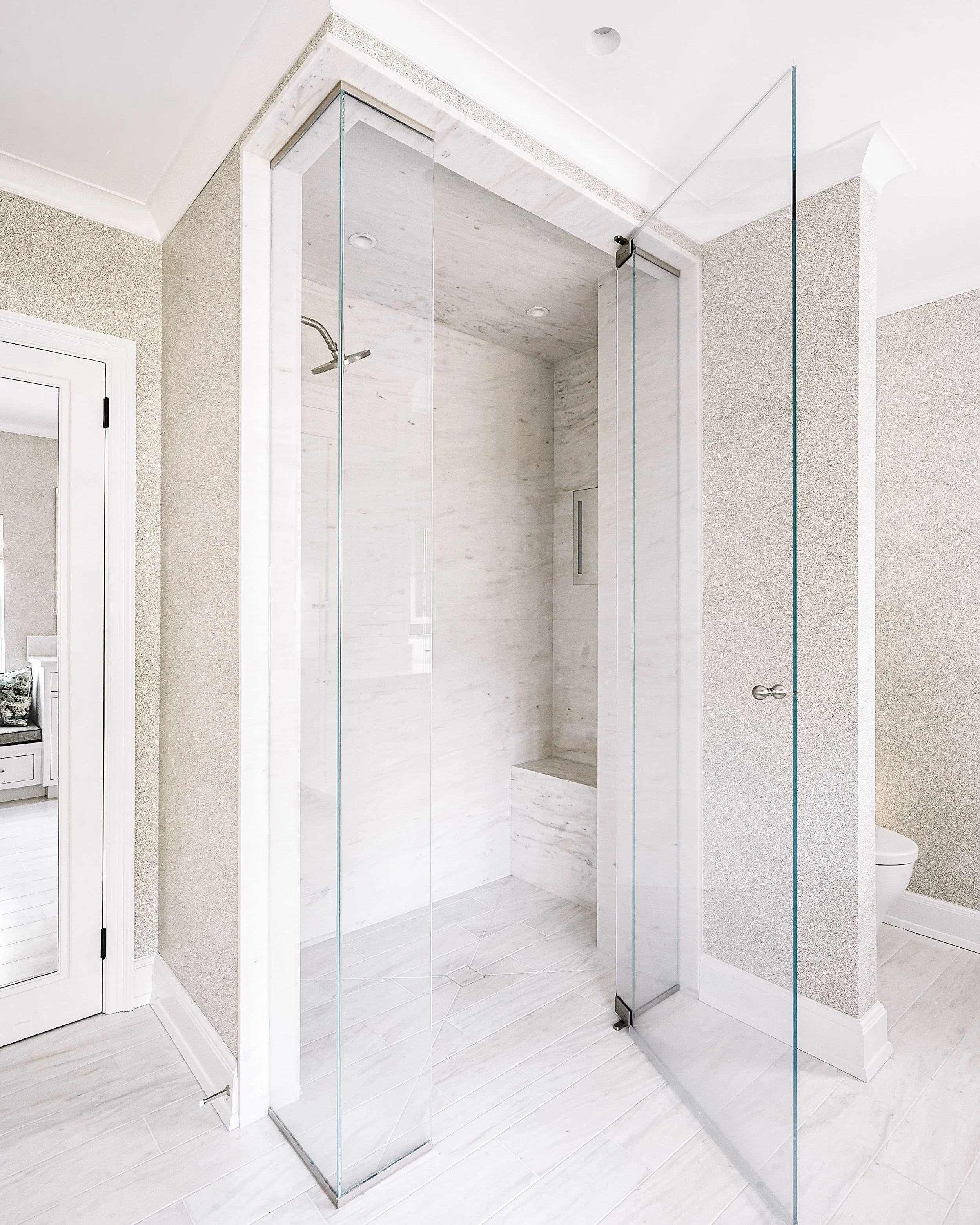 Luxury bathroom with marble shower and warm, layered finishes